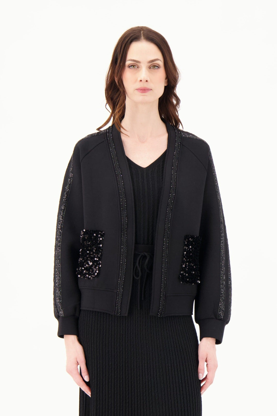 Woman wearing a black outfit with embellishments on a white background