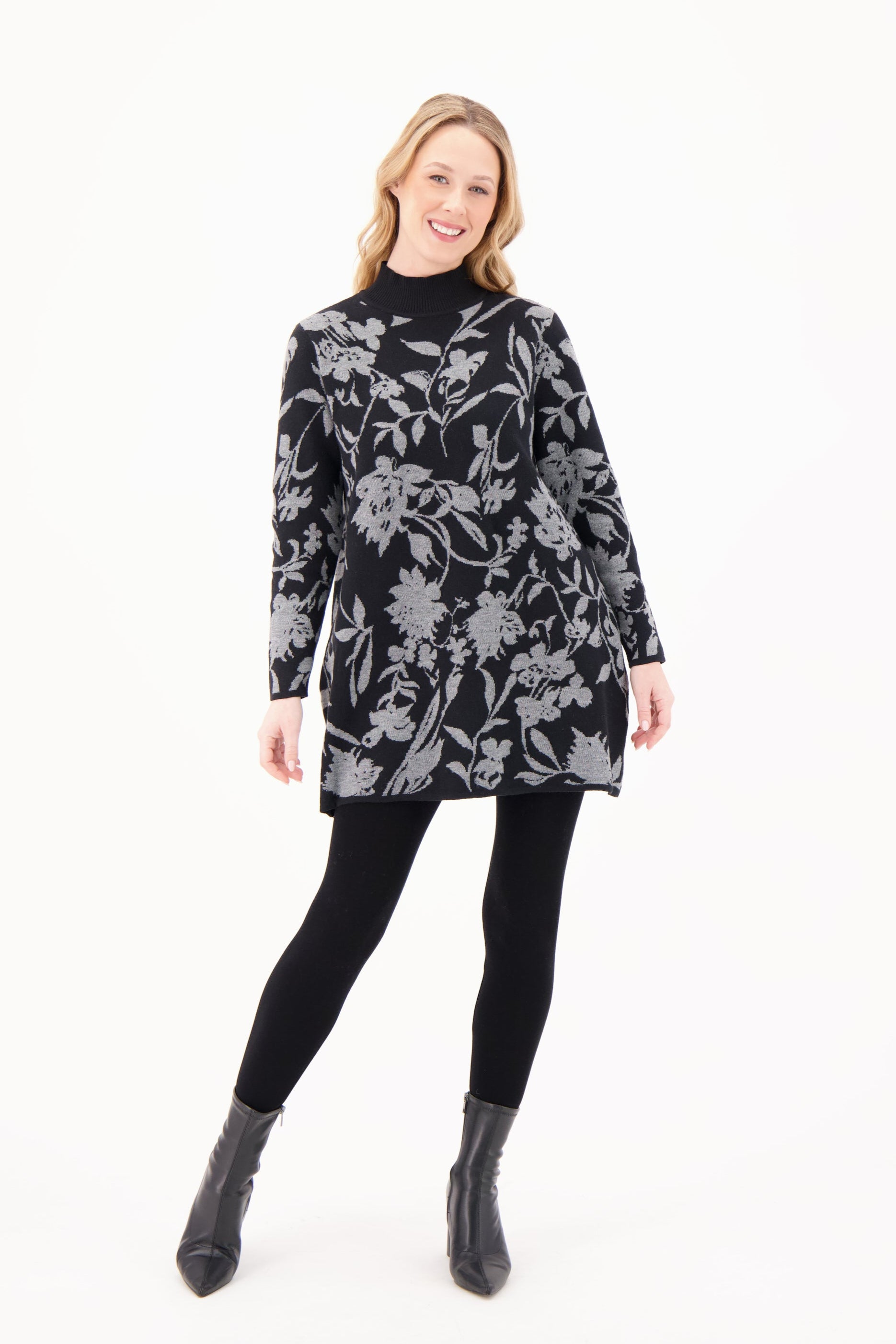 Woman wearing a black floral patterned dress on a white background