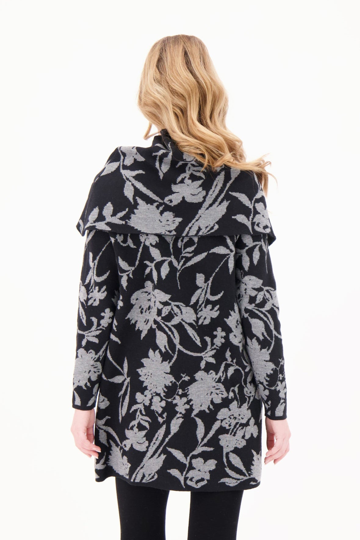 Woman wearing a black floral patterned coat on a white background