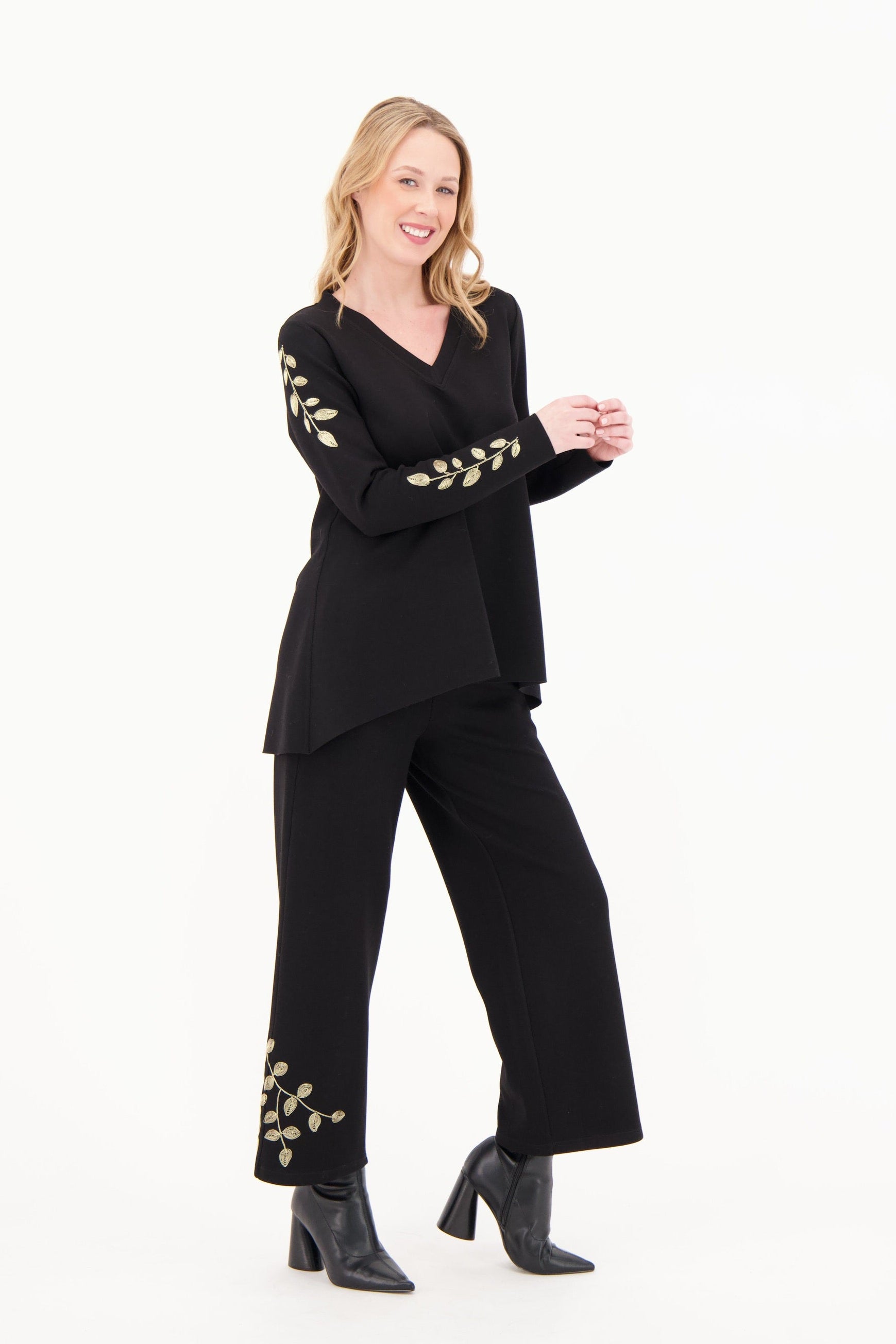 Woman wearing a black outfit with floral embellishments on a white background