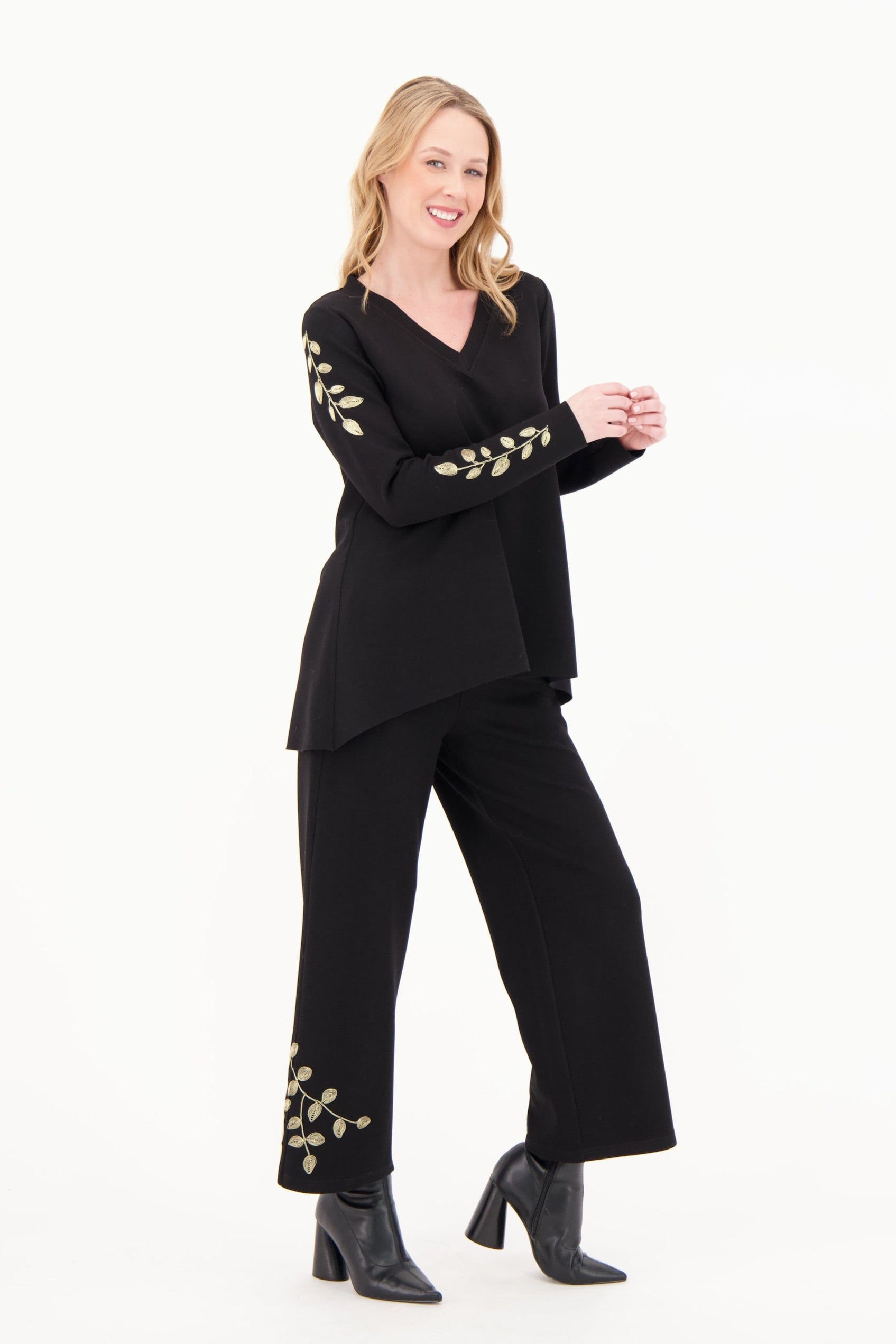 Woman wearing a black outfit with floral embellishments on a white background