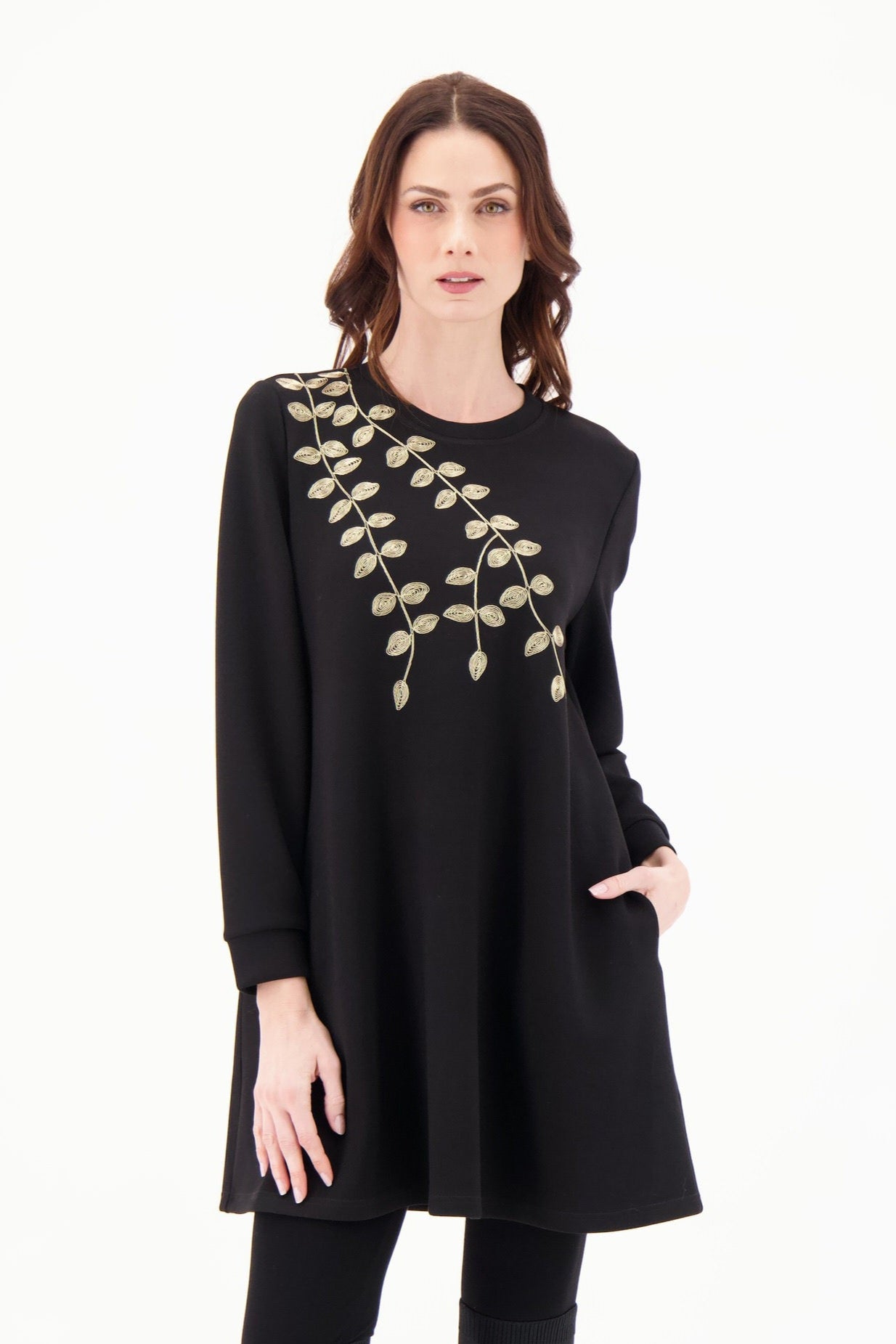 Woman wearing a black dress with floral embroidery on a white background