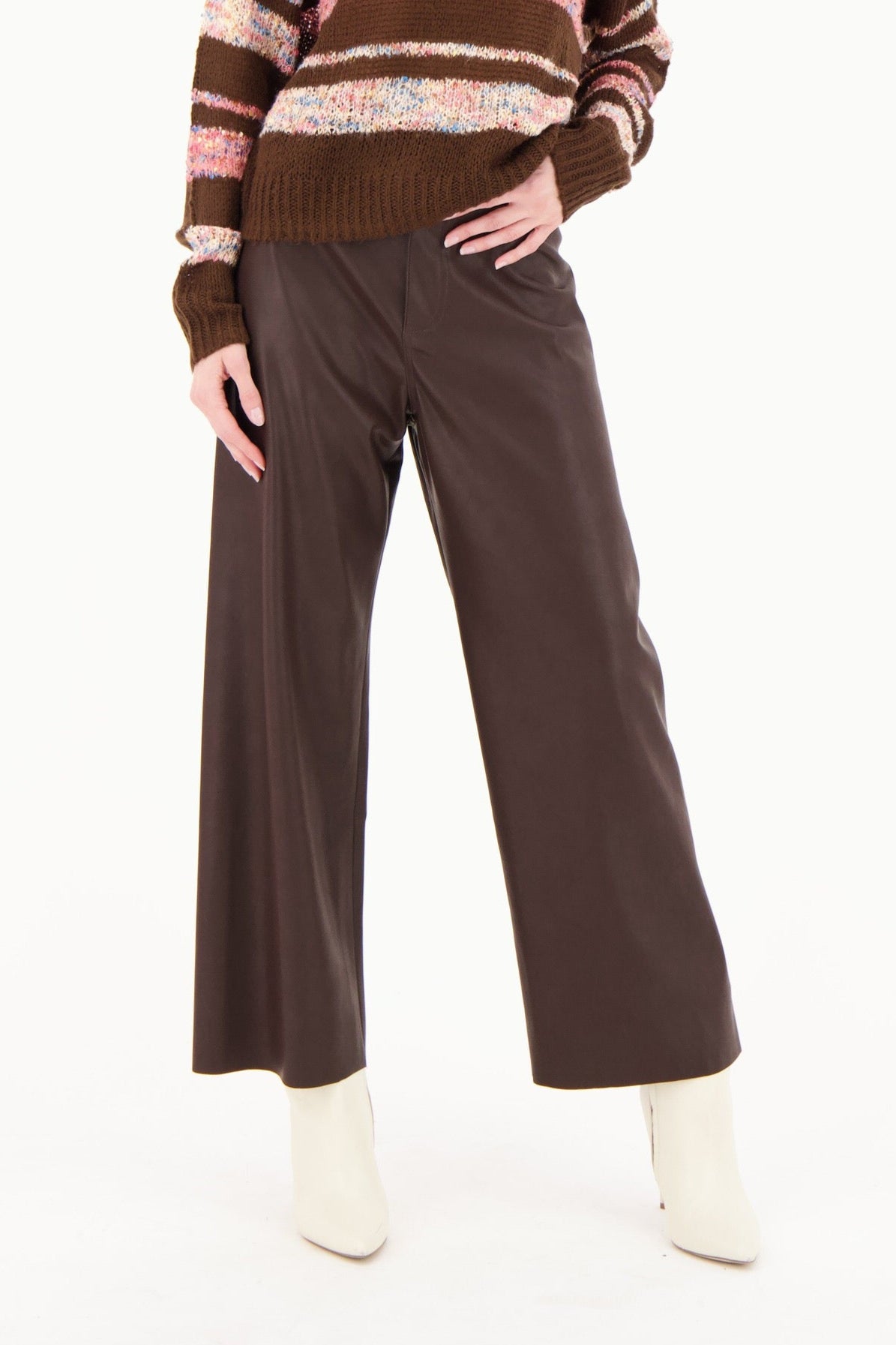 Woman wearing a brown striped sweater and brown pants on a white background