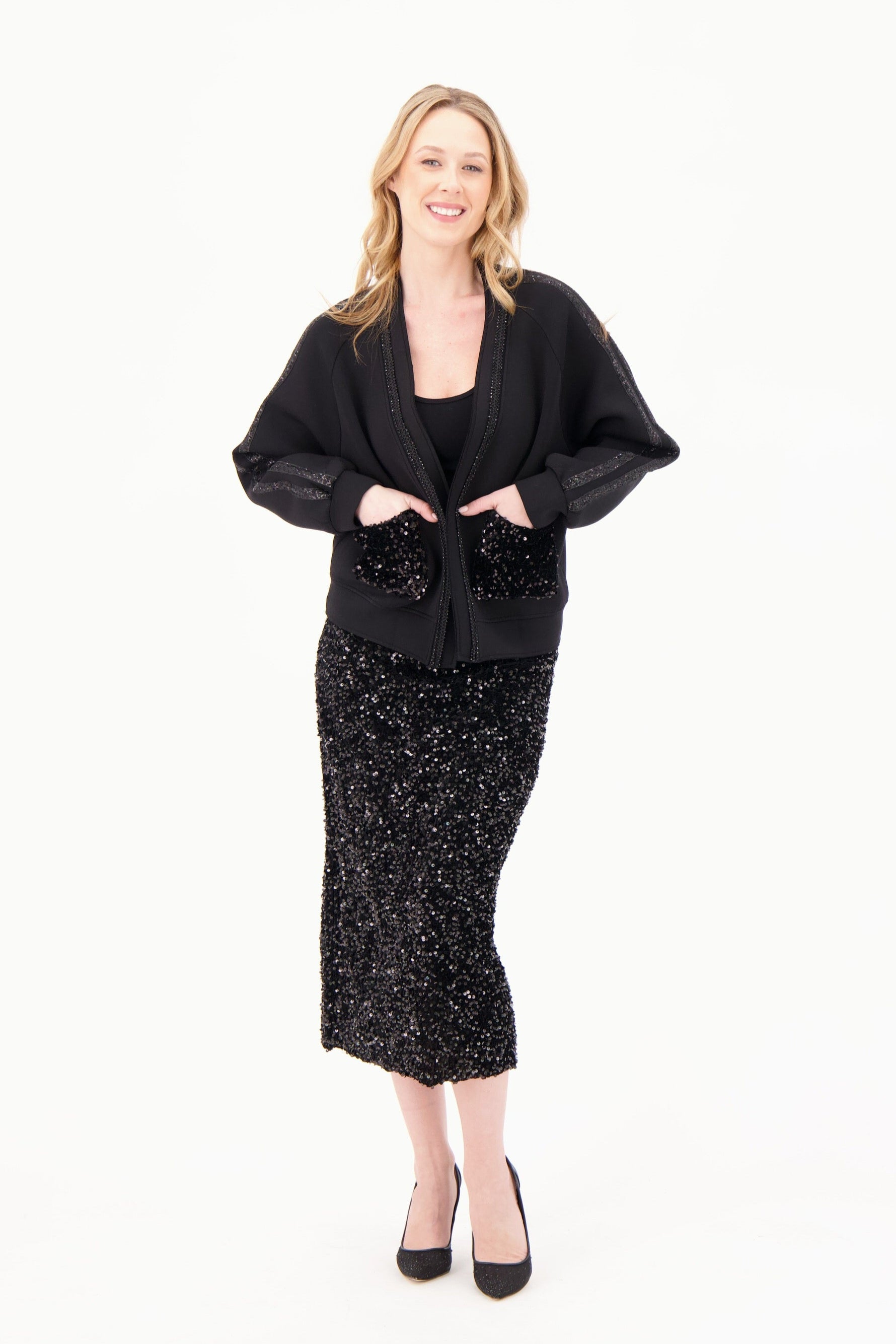 Woman wearing a black outfit with a sparkly skirt on a white background