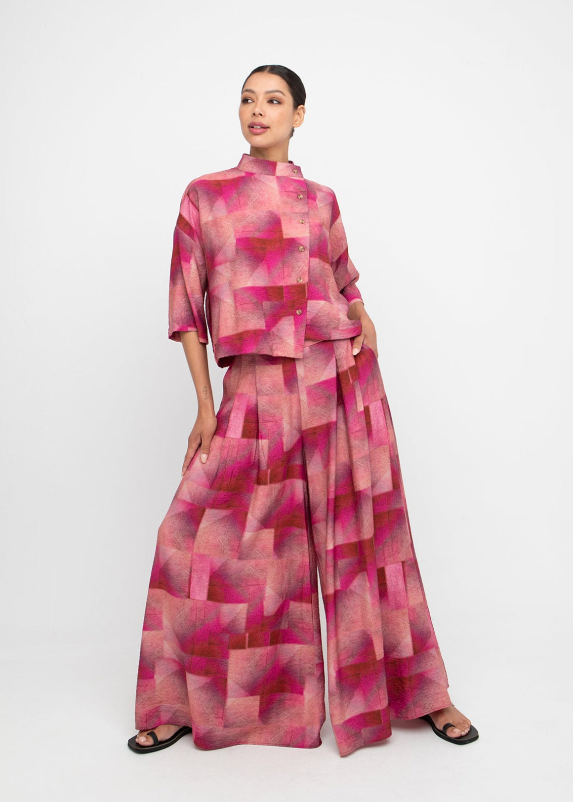 Woman wearing Ozai N Ku Spring 2026 pink geometric patterned outfit on a white background