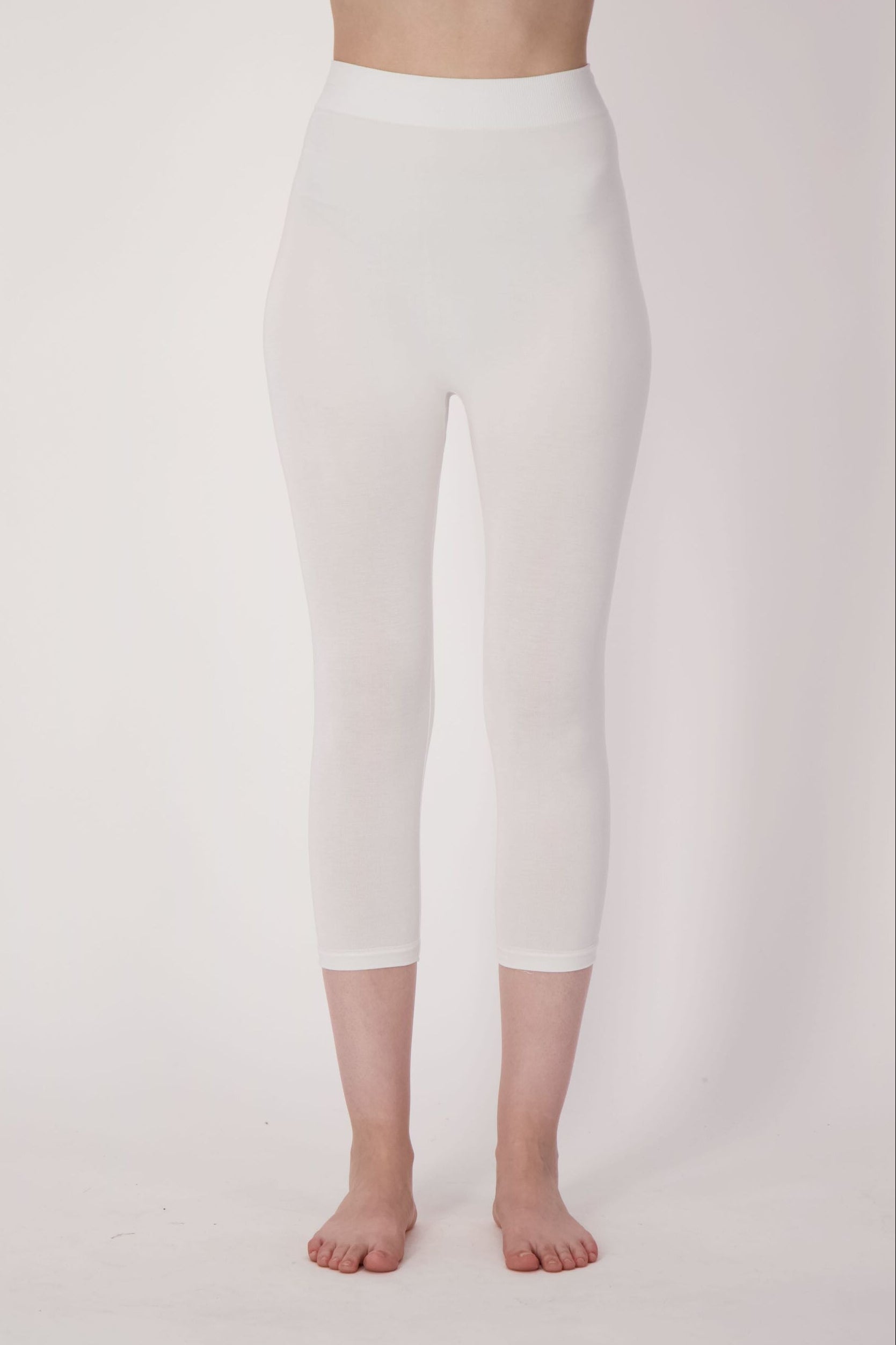 Person wearing white leggings on a plain background