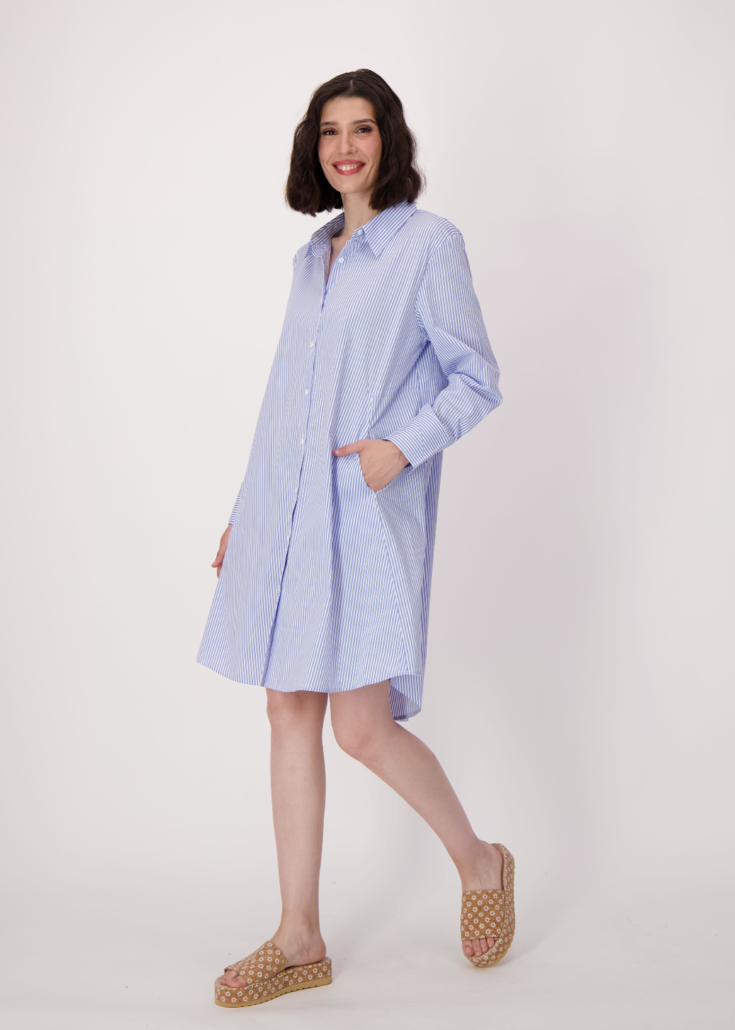 Woman wearing a light blue dress with a white background
