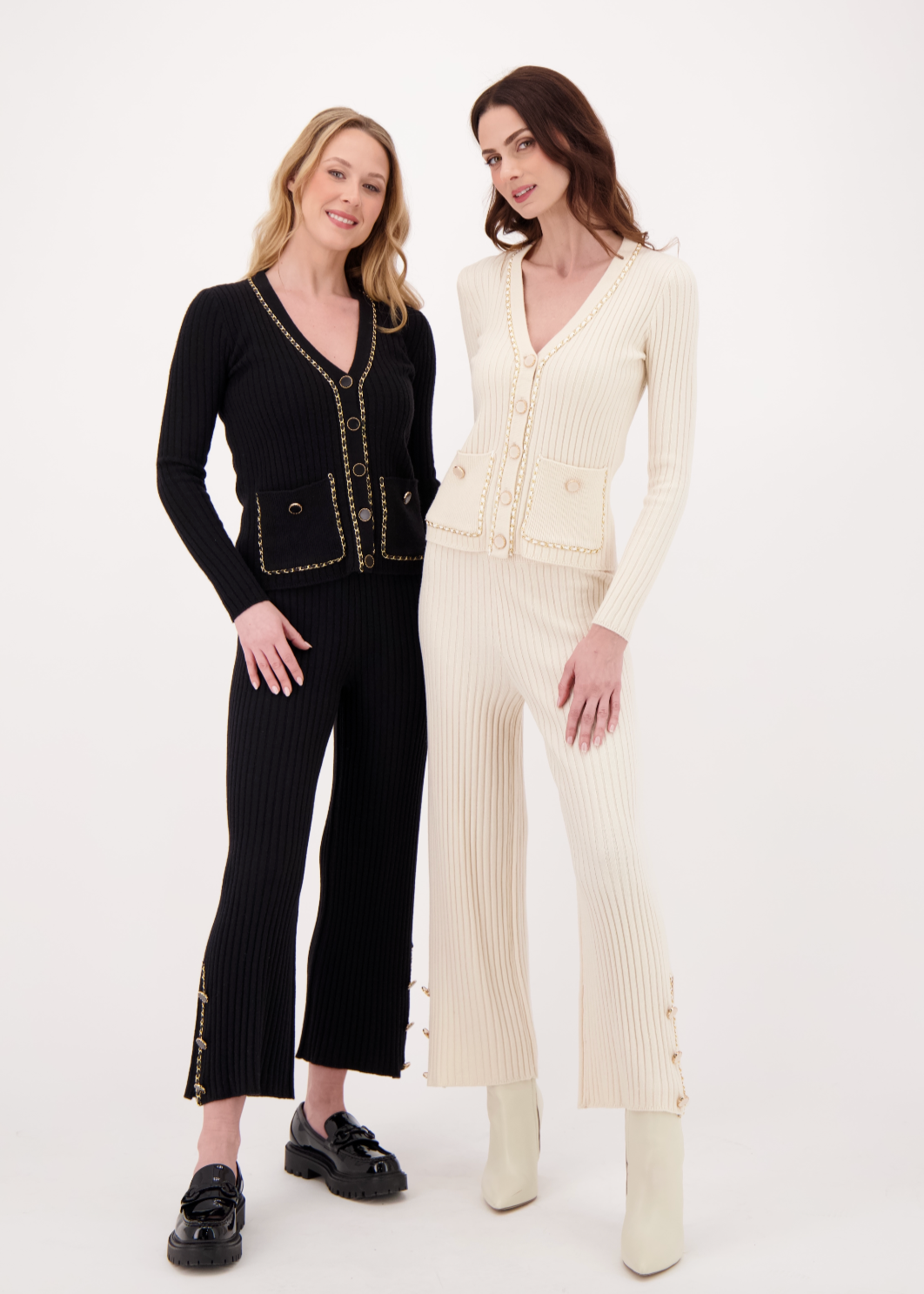 Two women wearing black and white outfits on a white background