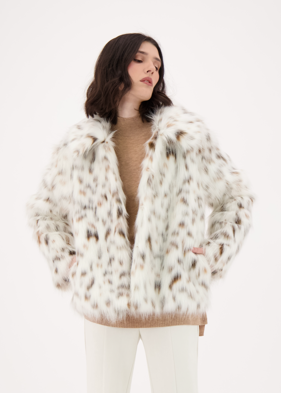 Woman wearing a white fur coat on a white background