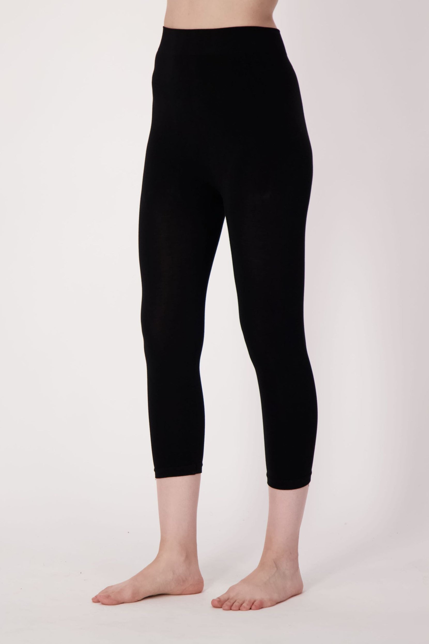 Person wearing black leggings on a white background