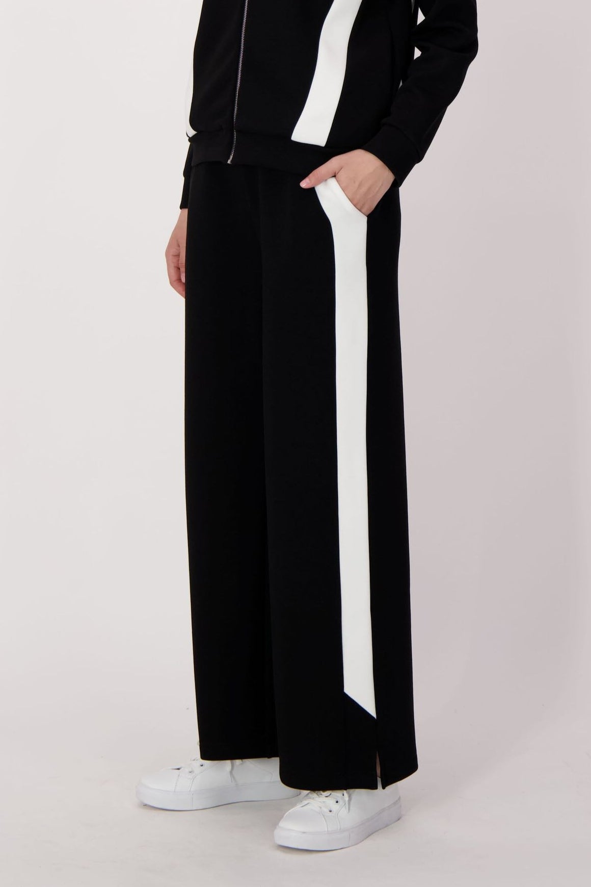Person wearing a black and white outfit with a white background