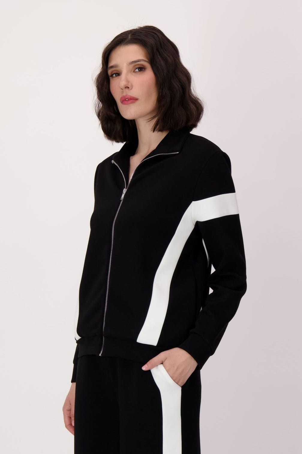 Person wearing a black and white outfit with a white background