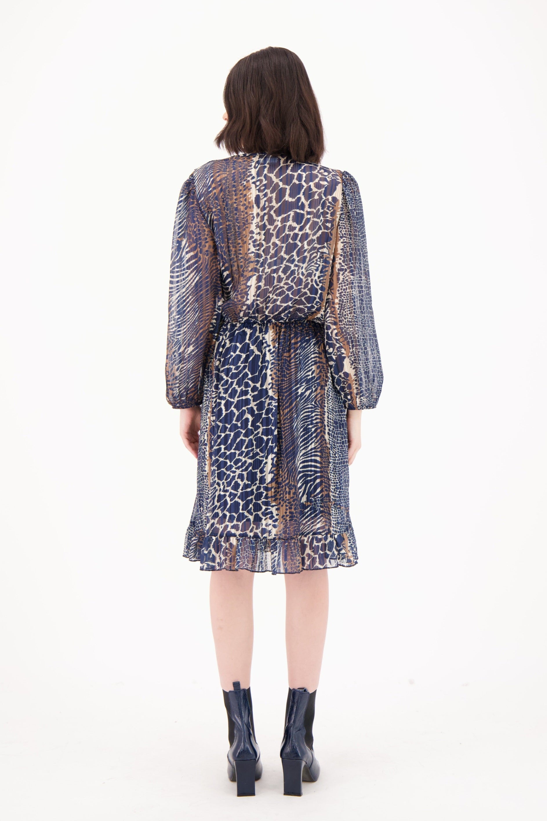 Woman wearing a patterned dress with a white background