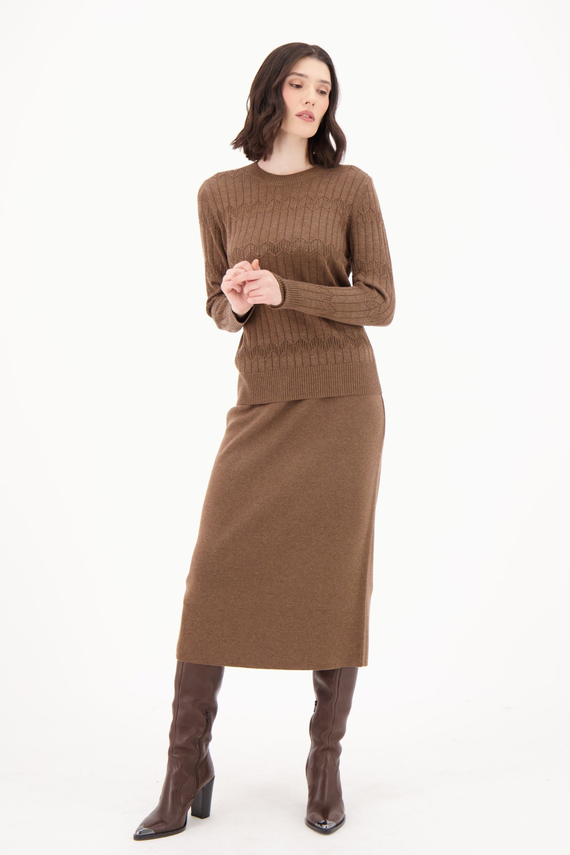 Woman wearing a brown sweater and skirt set on a white background
