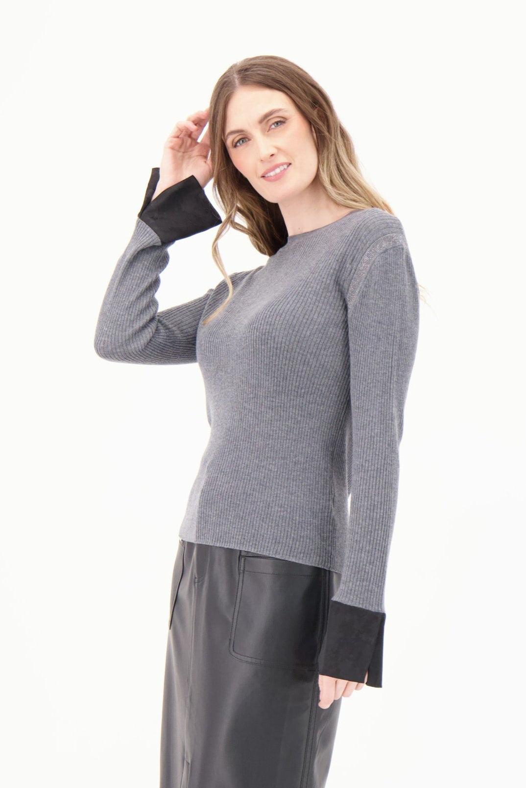 Woman wearing a gray sweater with black cuffs and hem on a white background