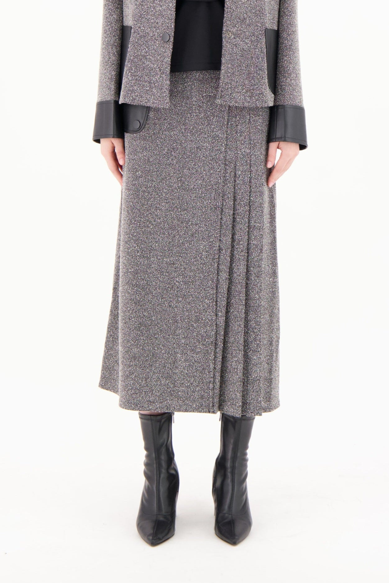 Woman wearing a gray coat and skirt set on a white background