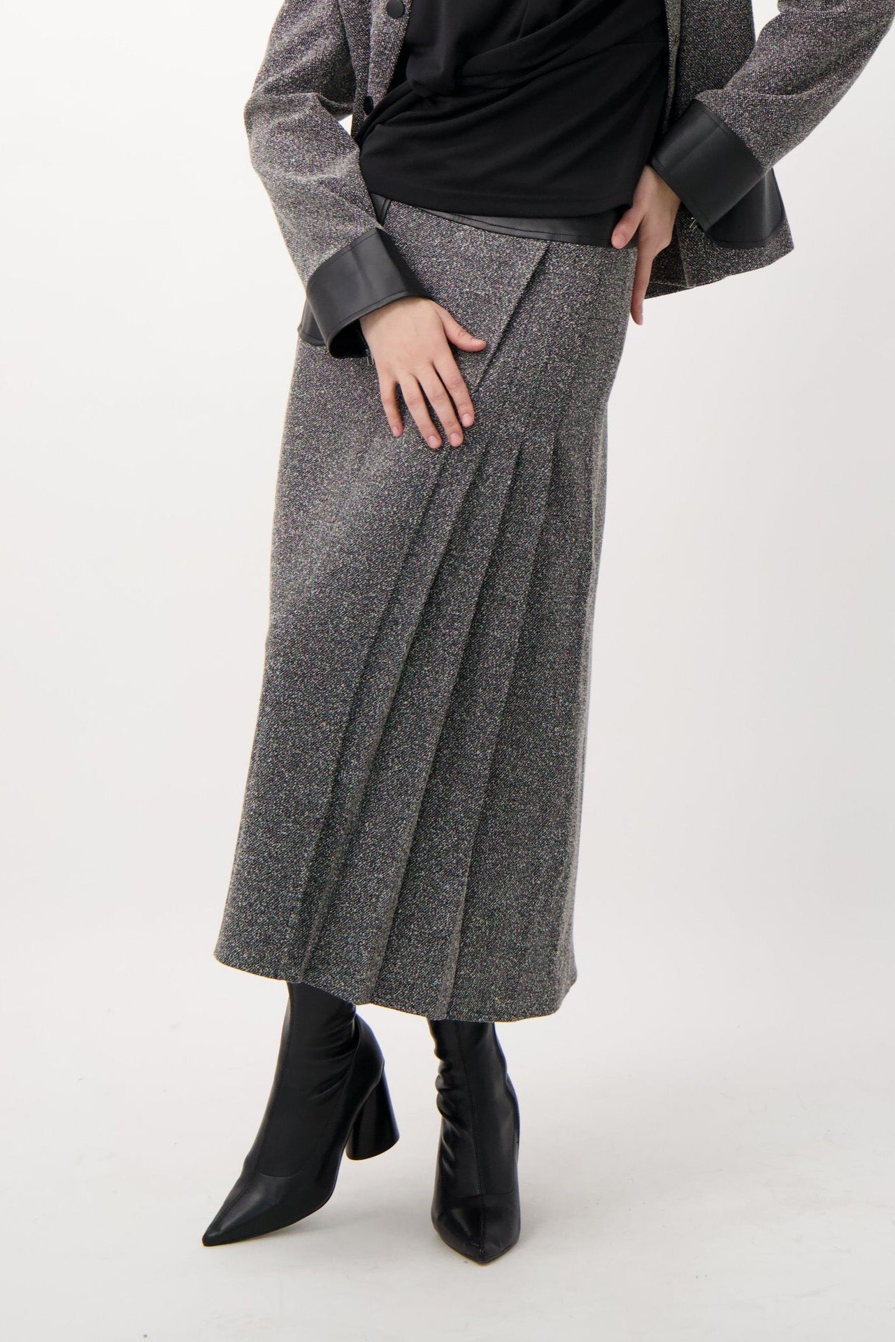Woman wearing a gray coat and black top on a white background