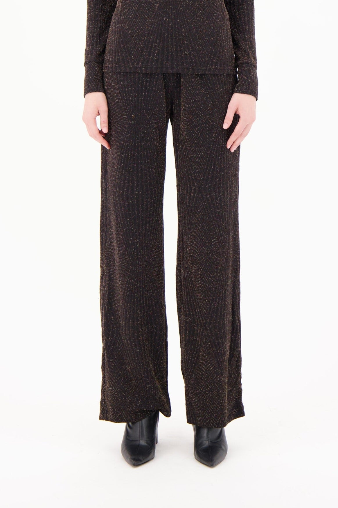 Brown ribbed knit pants worn by a person on a white background