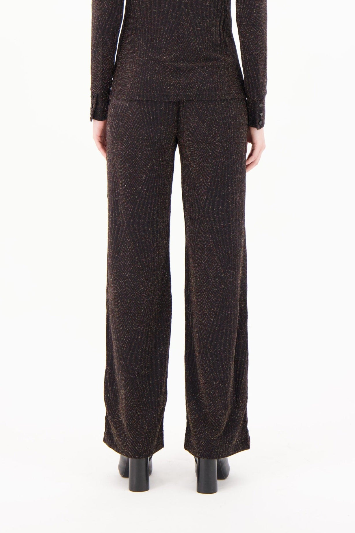 Brown ribbed knit pants worn by a person on a white background