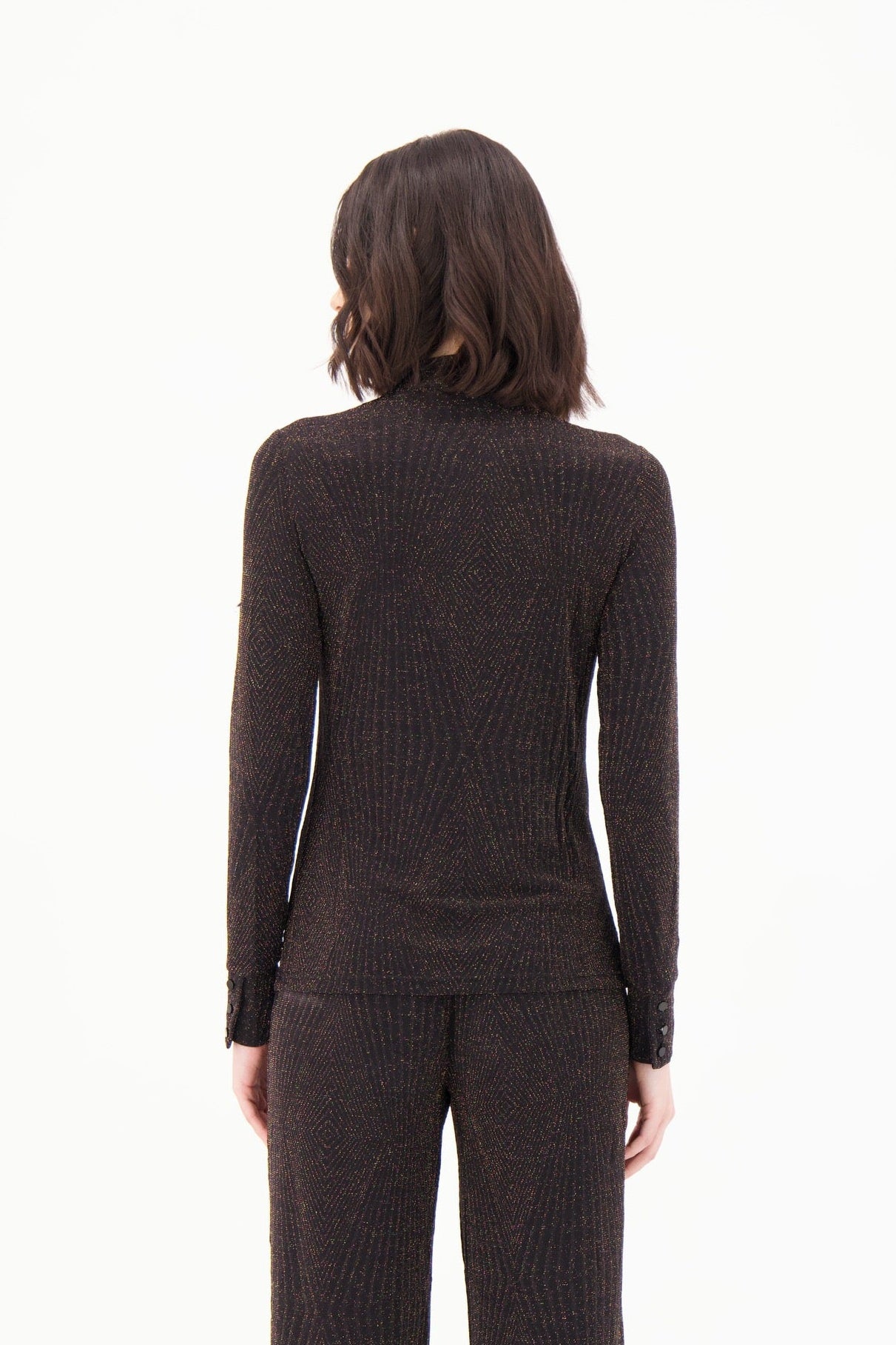 Person wearing a brown ribbed sweater and pants on a white background