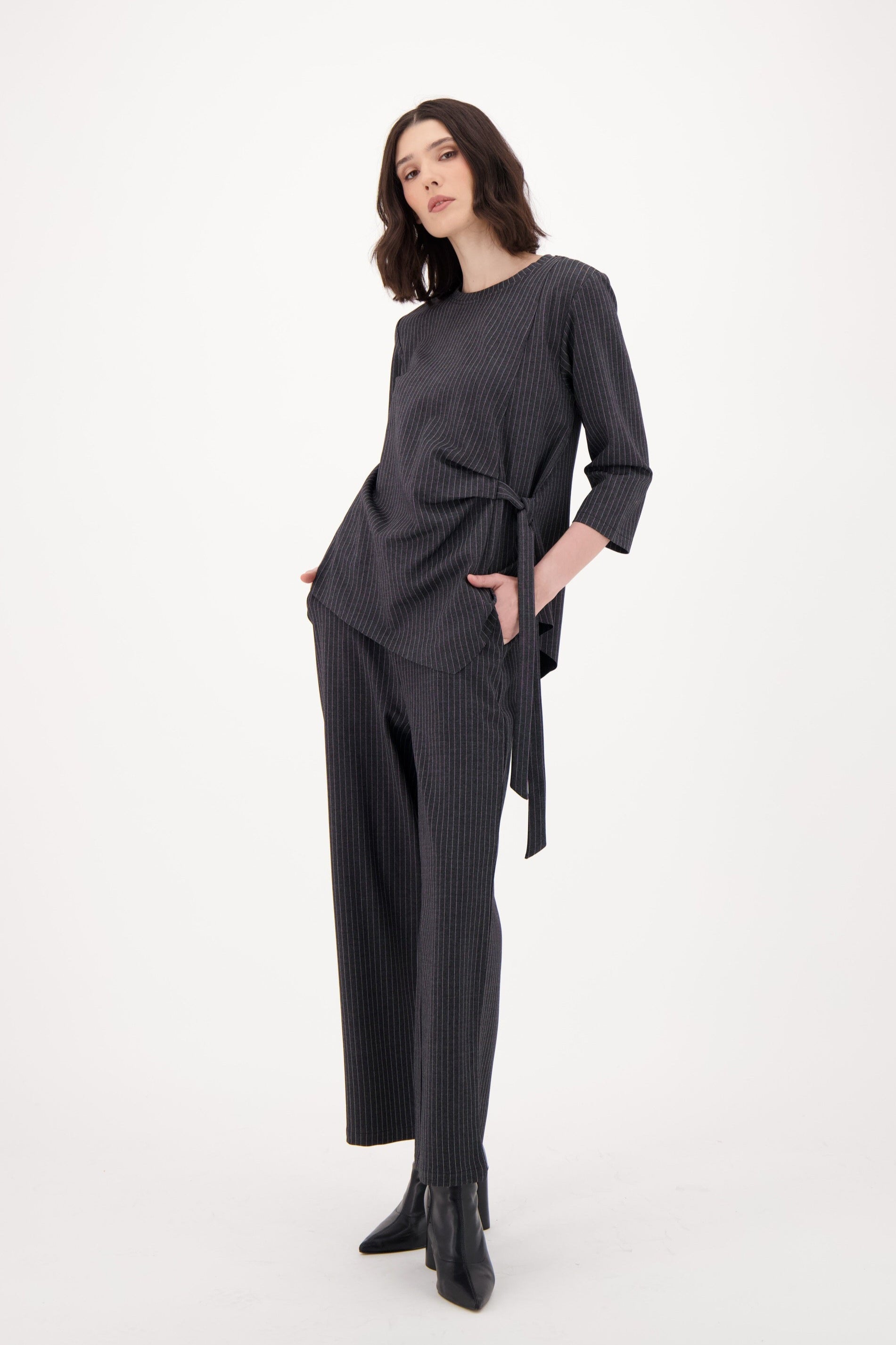 Woman wearing a dark gray outfit on a white background