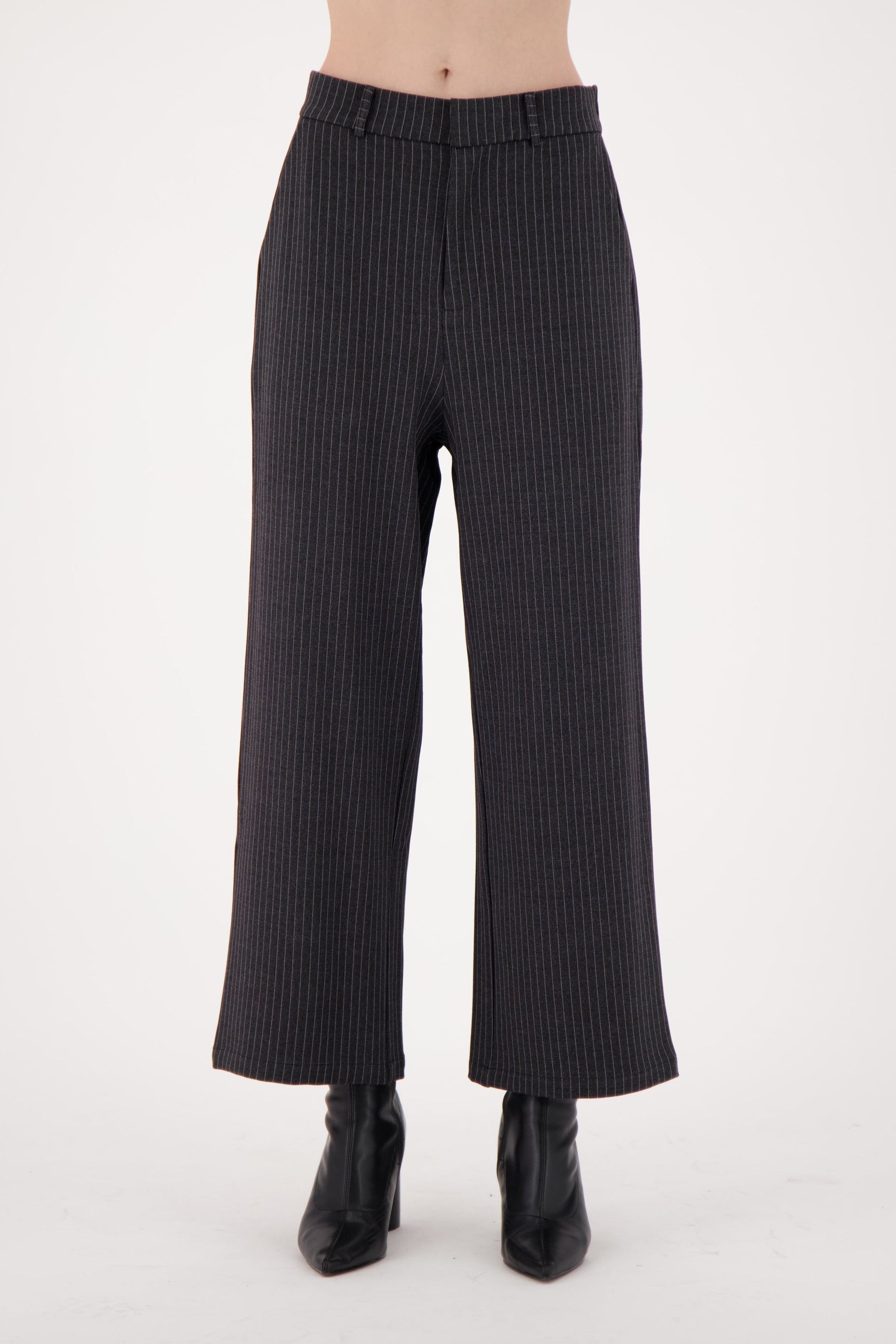 Black ribbed pants worn by a person on a white background