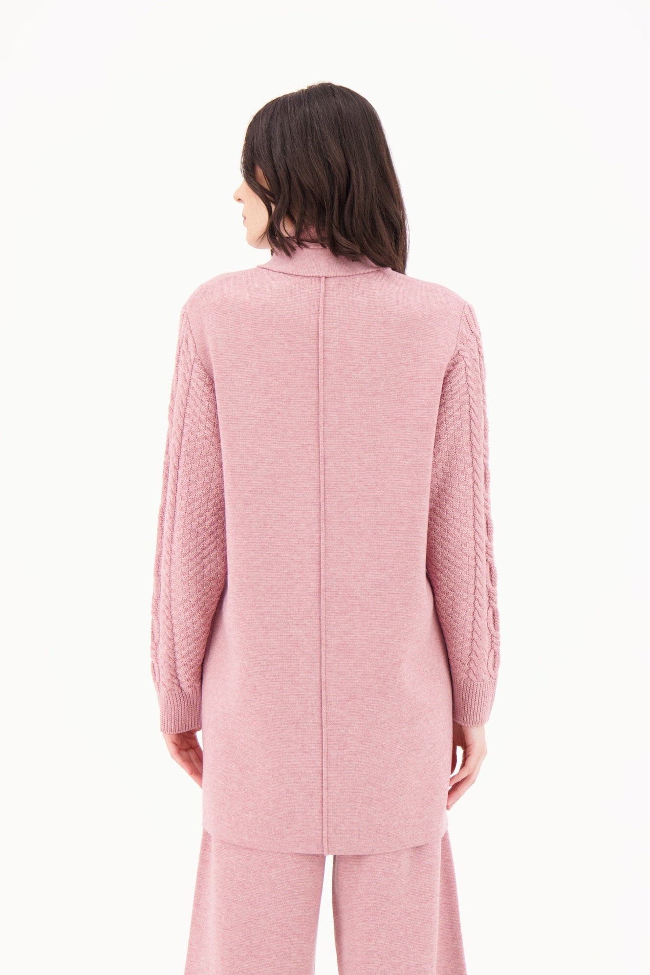 Person wearing a pink outfit on a white background