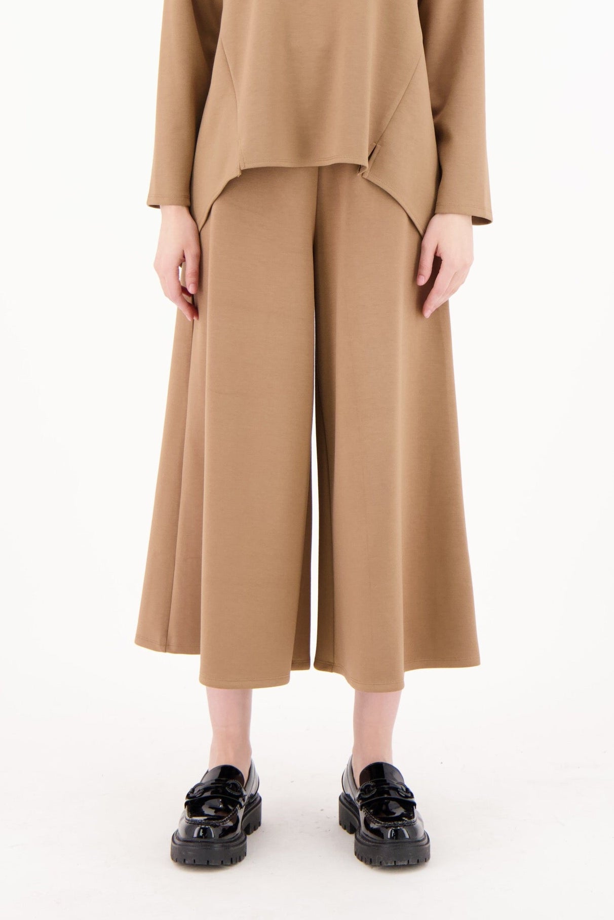 Woman wearing a brown outfit on a white background