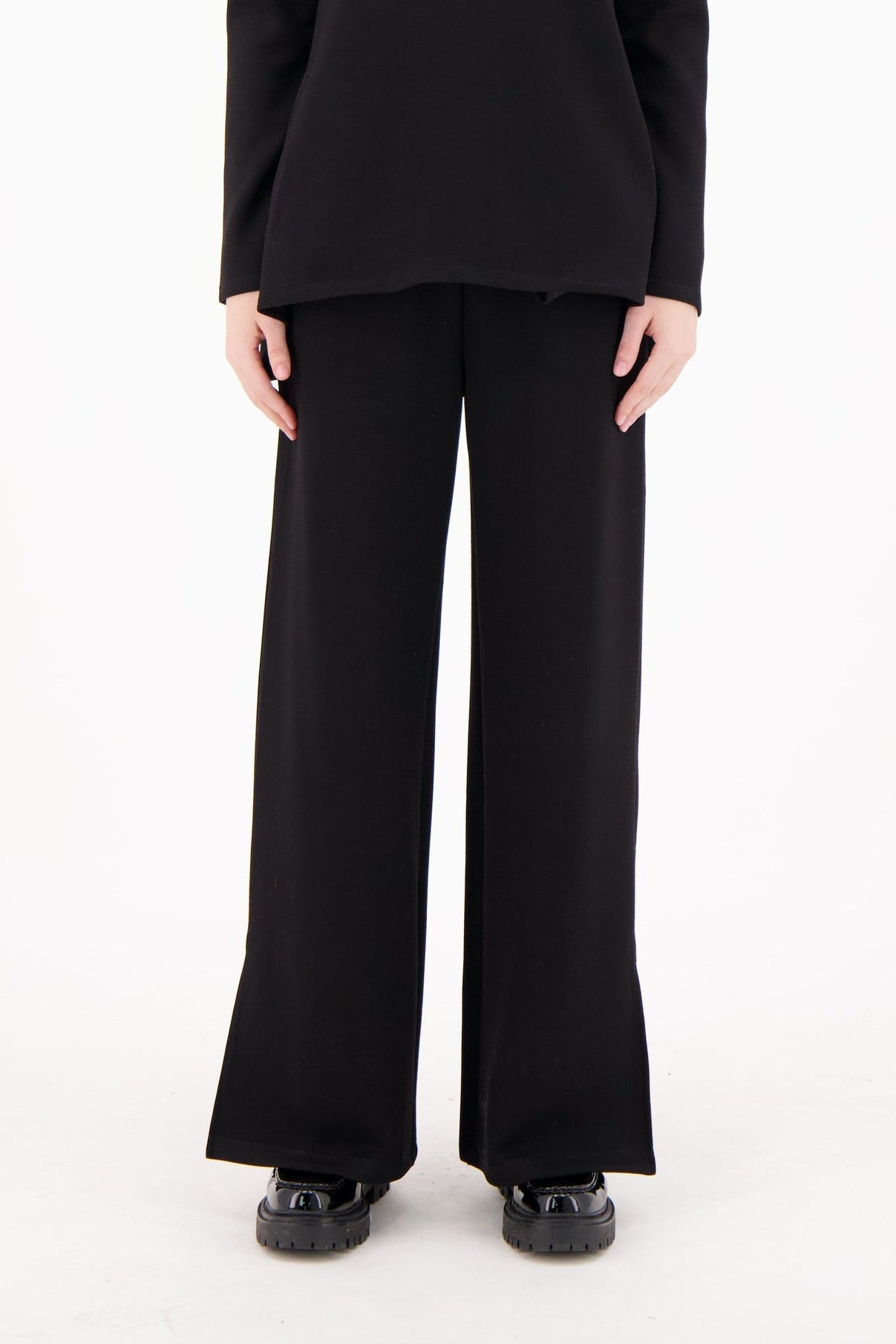Woman wearing a black outfit on a white background