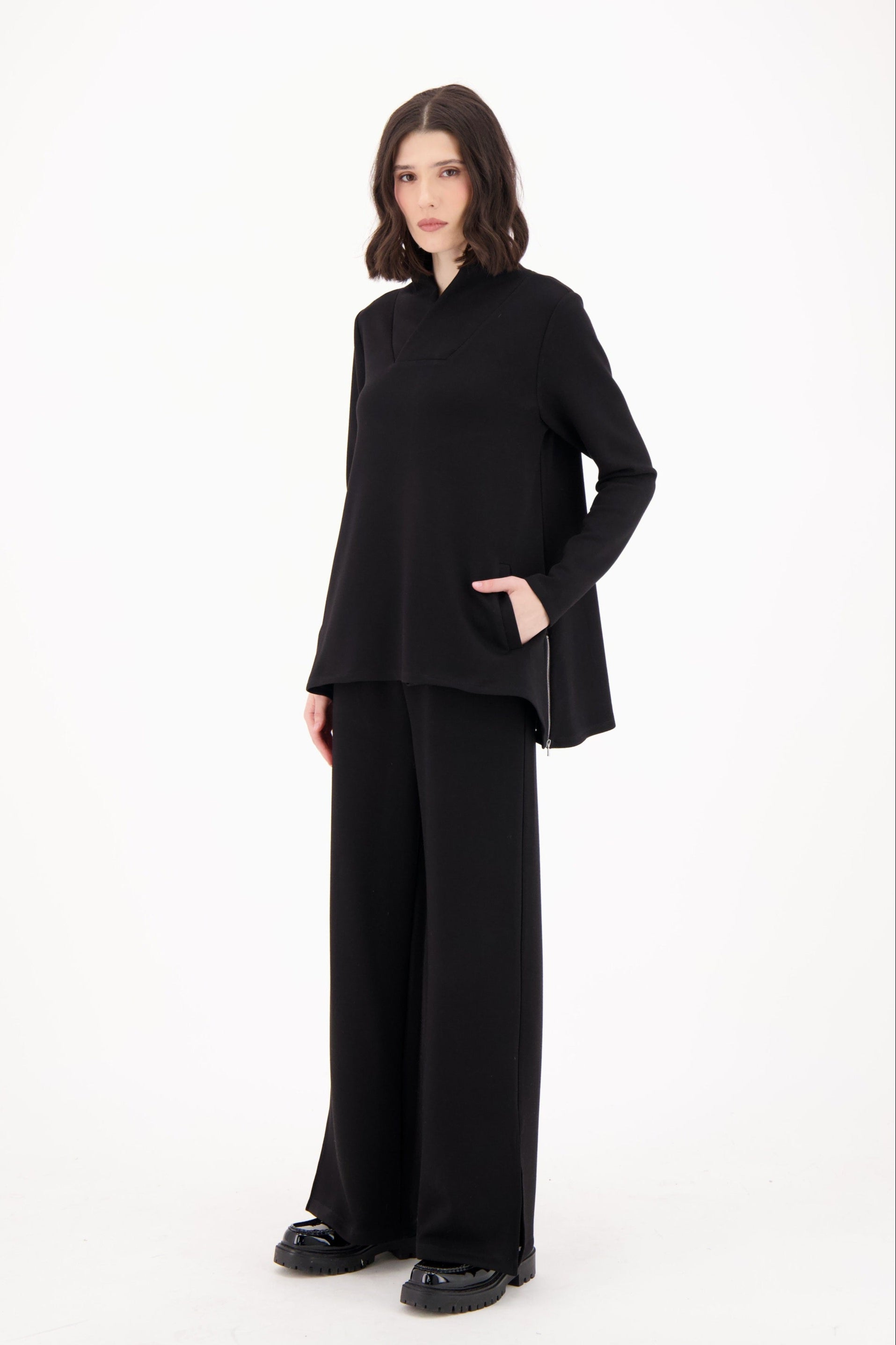 Woman wearing a black outfit on a white background