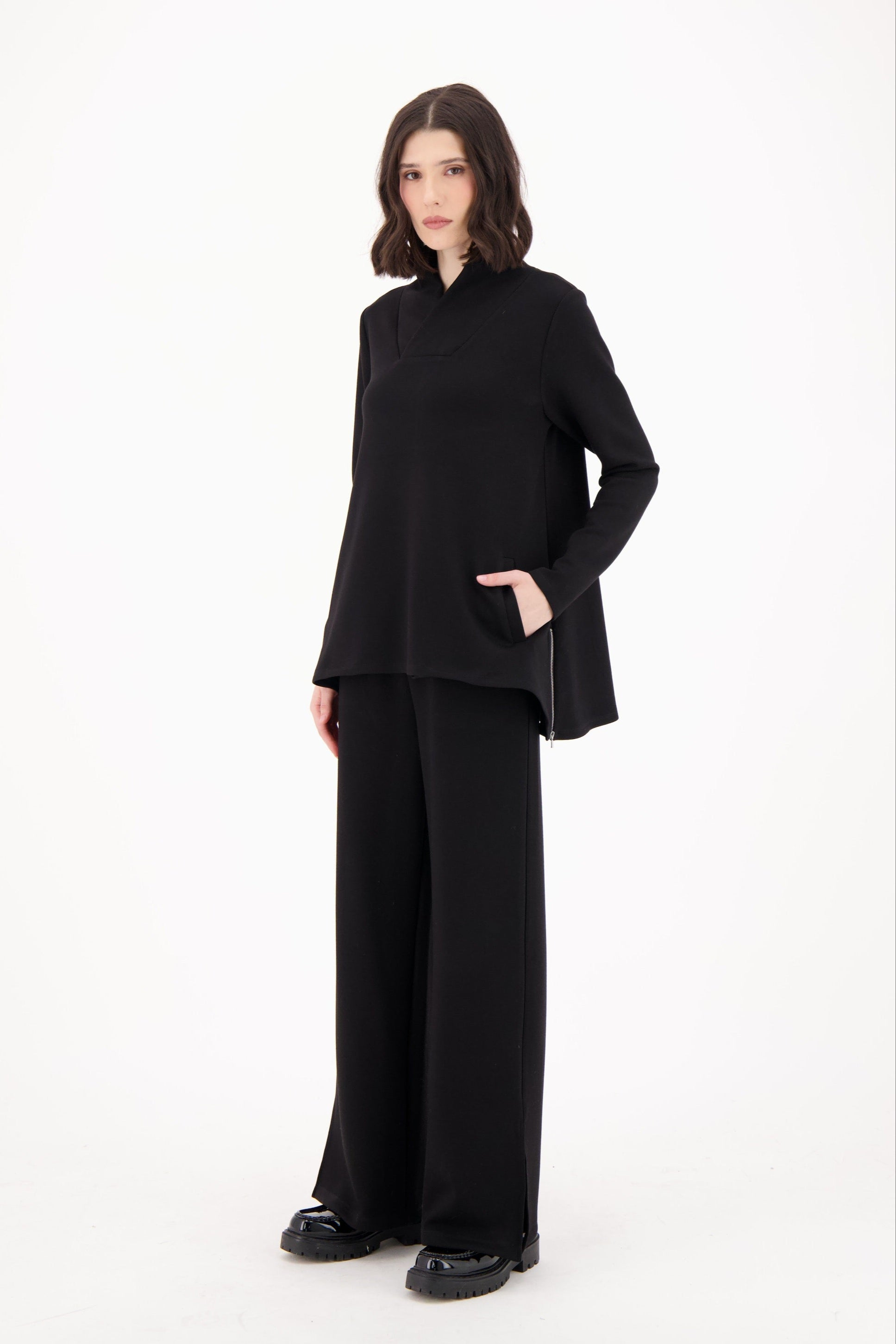 Woman wearing a black outfit on a white background