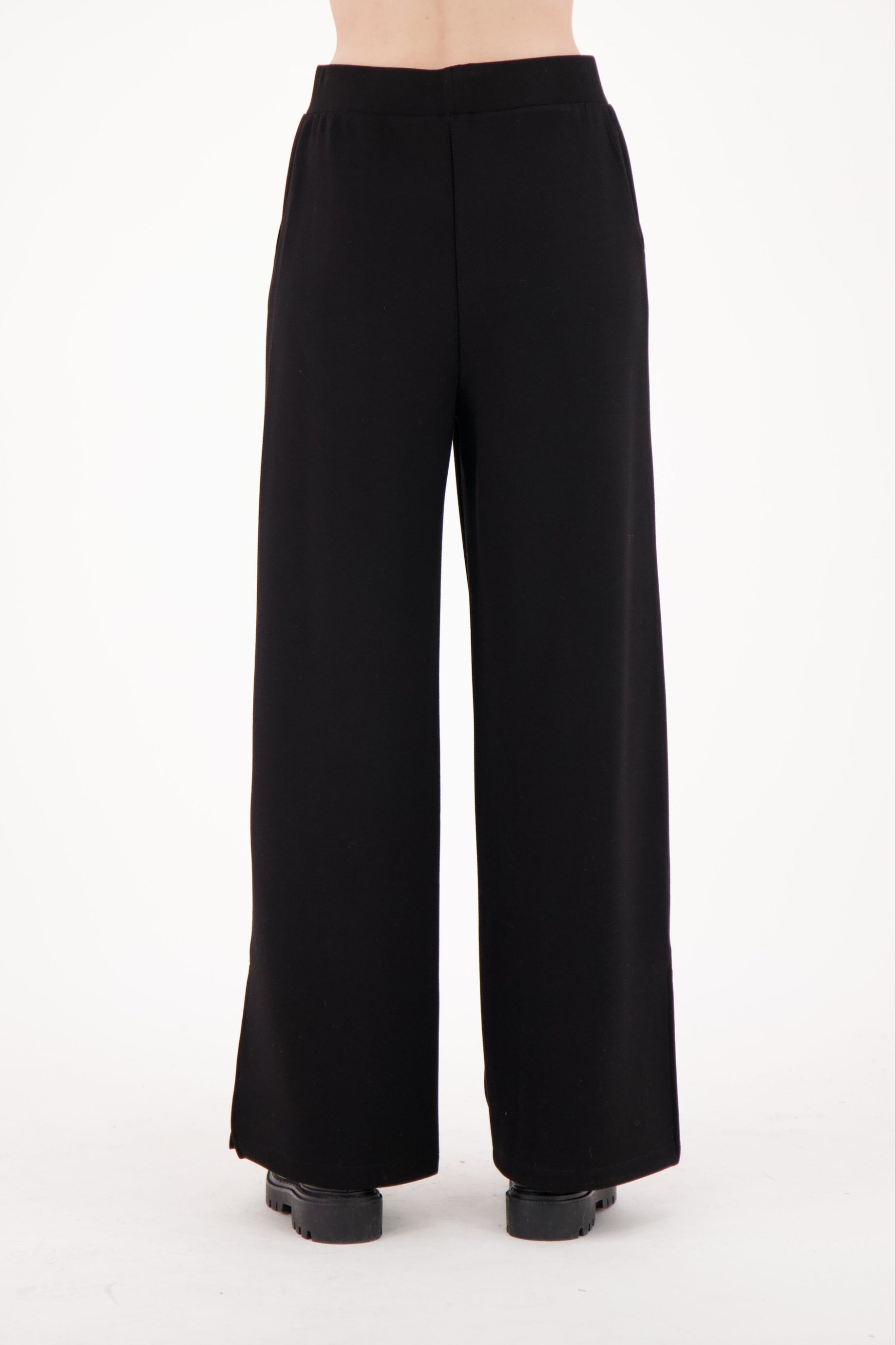 Black wide-leg pants worn by a person on a white background