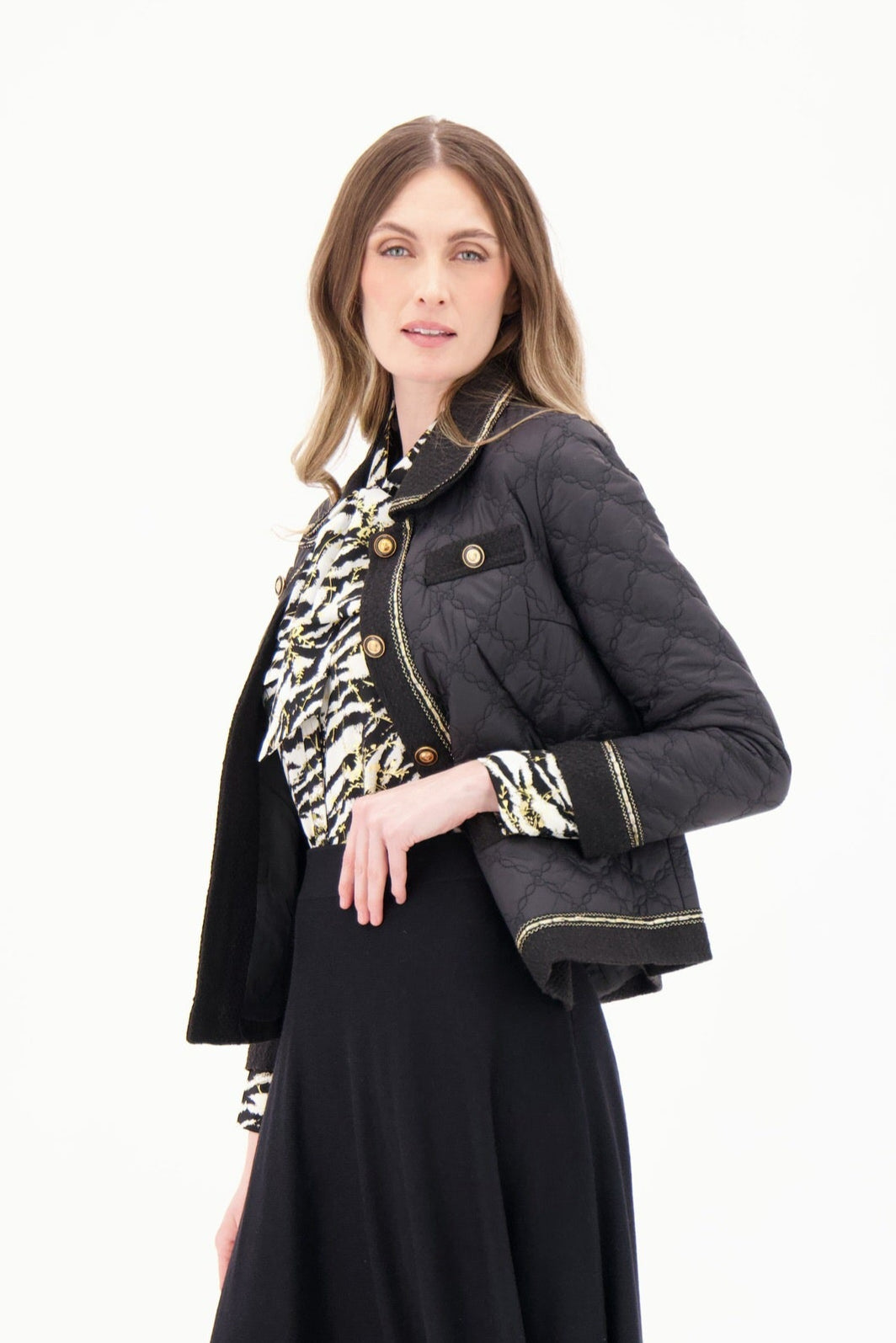 Woman wearing a black jacket, black skirt, and black boots on a white background