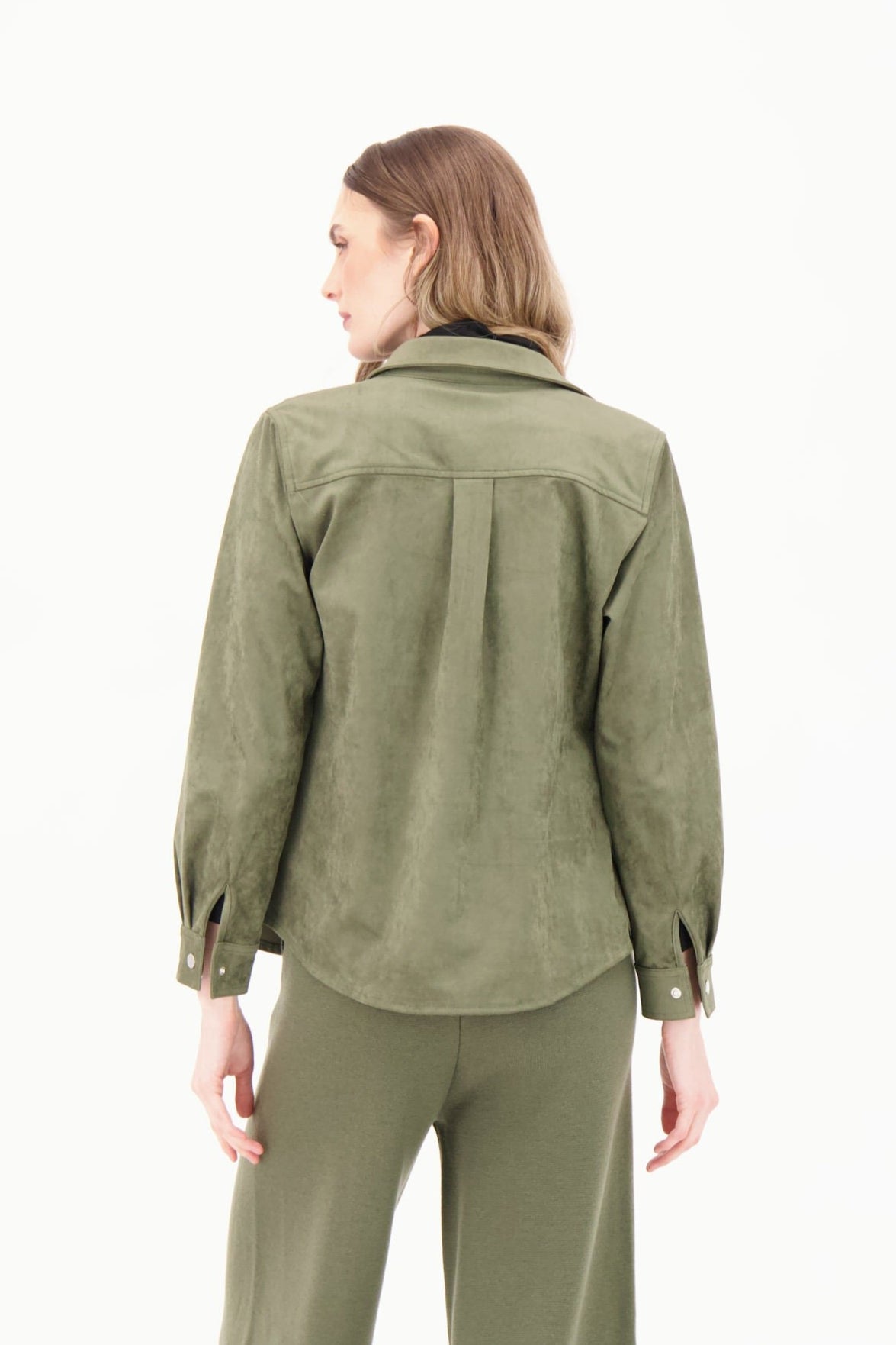 Woman wearing a green jacket and pants on a white background