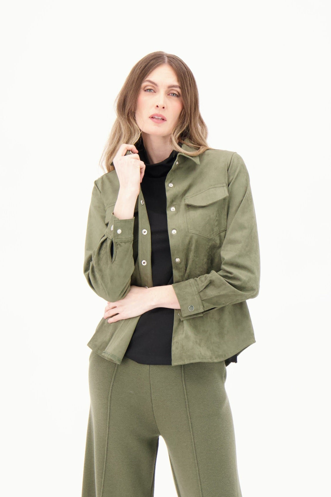 Woman wearing a green jacket and pants set on a white background