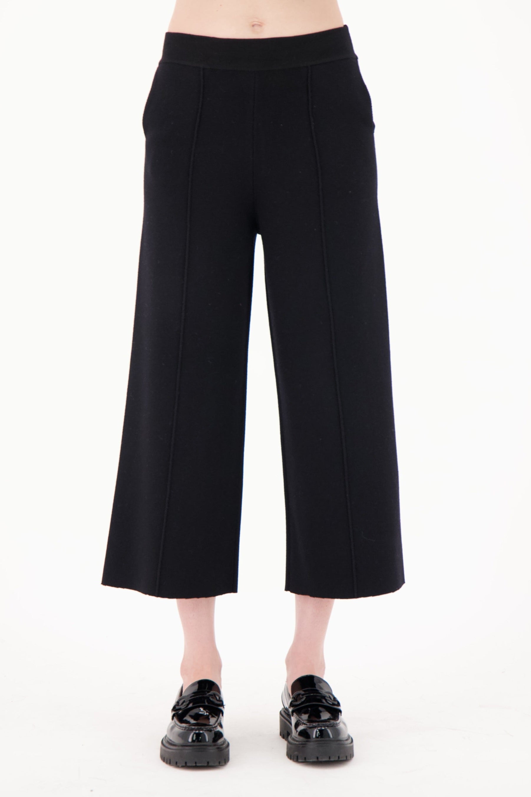 Black wide-leg pants worn by a person on a white background
