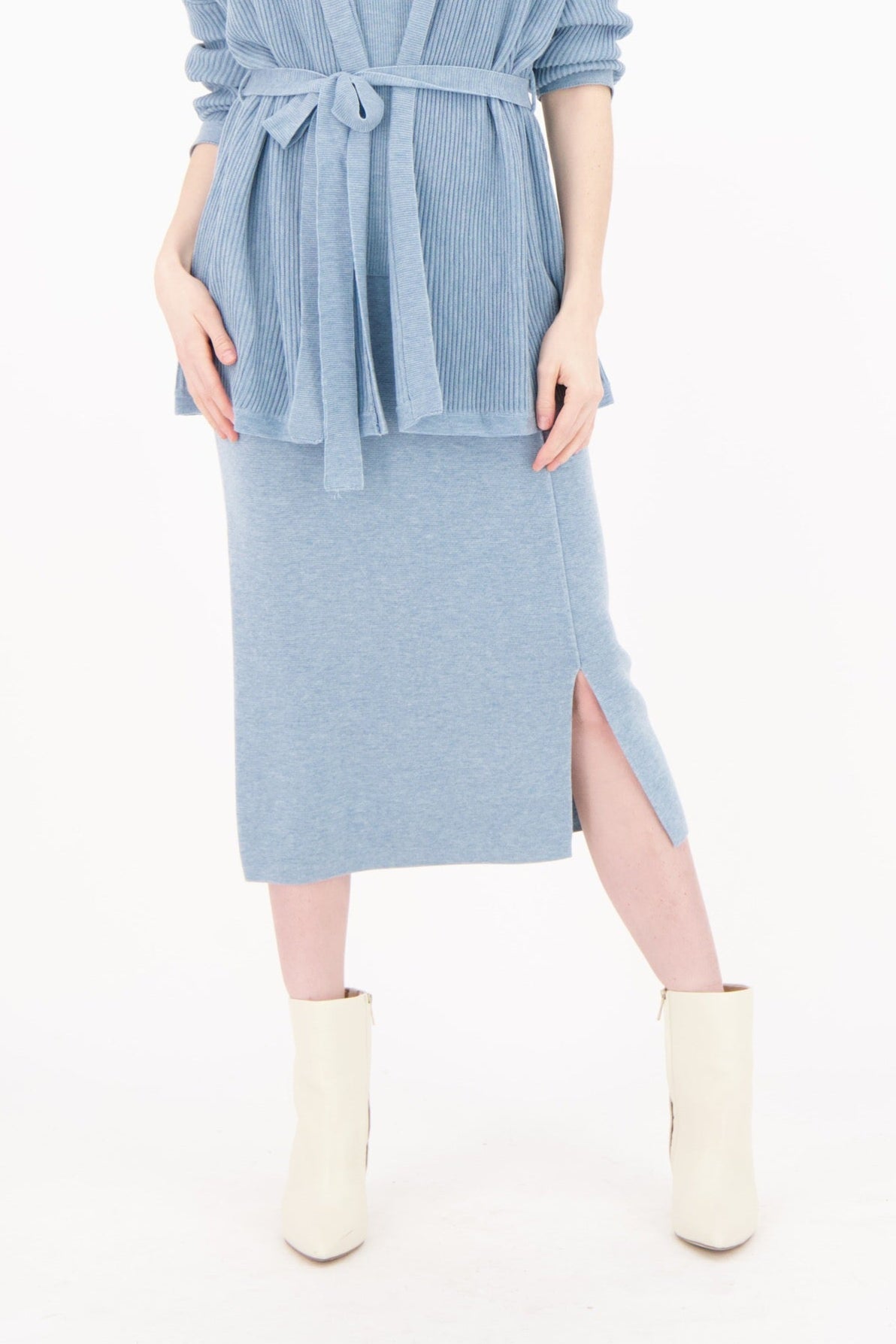 Woman wearing a light blue dress with a belt on a white background