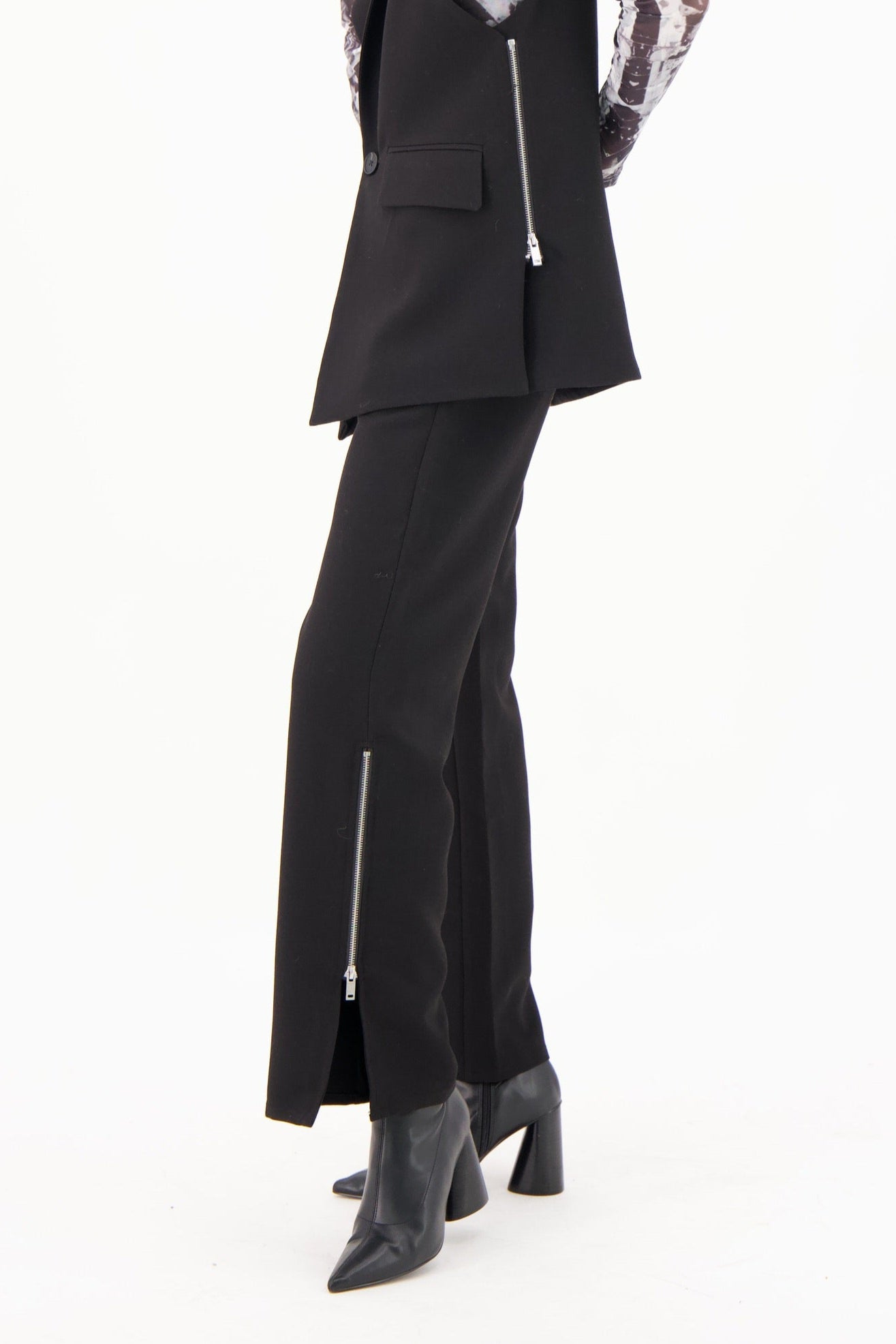 Woman wearing a black outfit with a sequin jacket on a white background