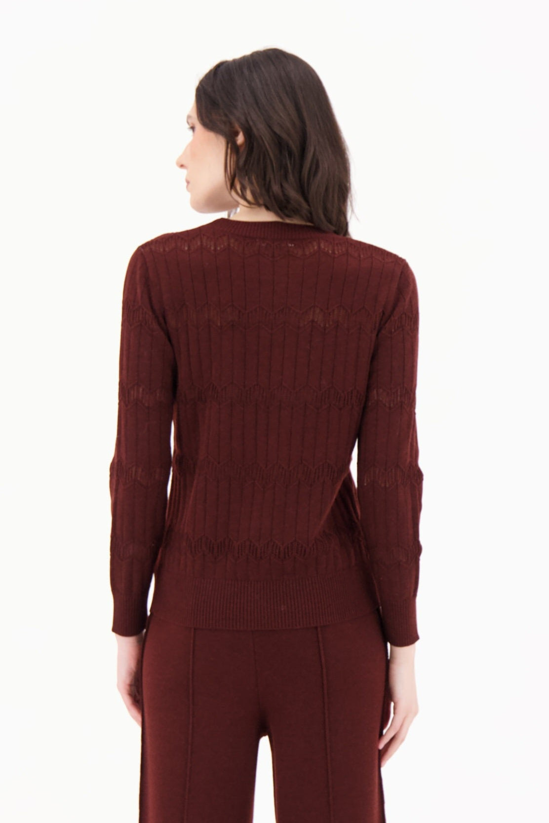 Woman wearing a maroon jumpsuit on a white background