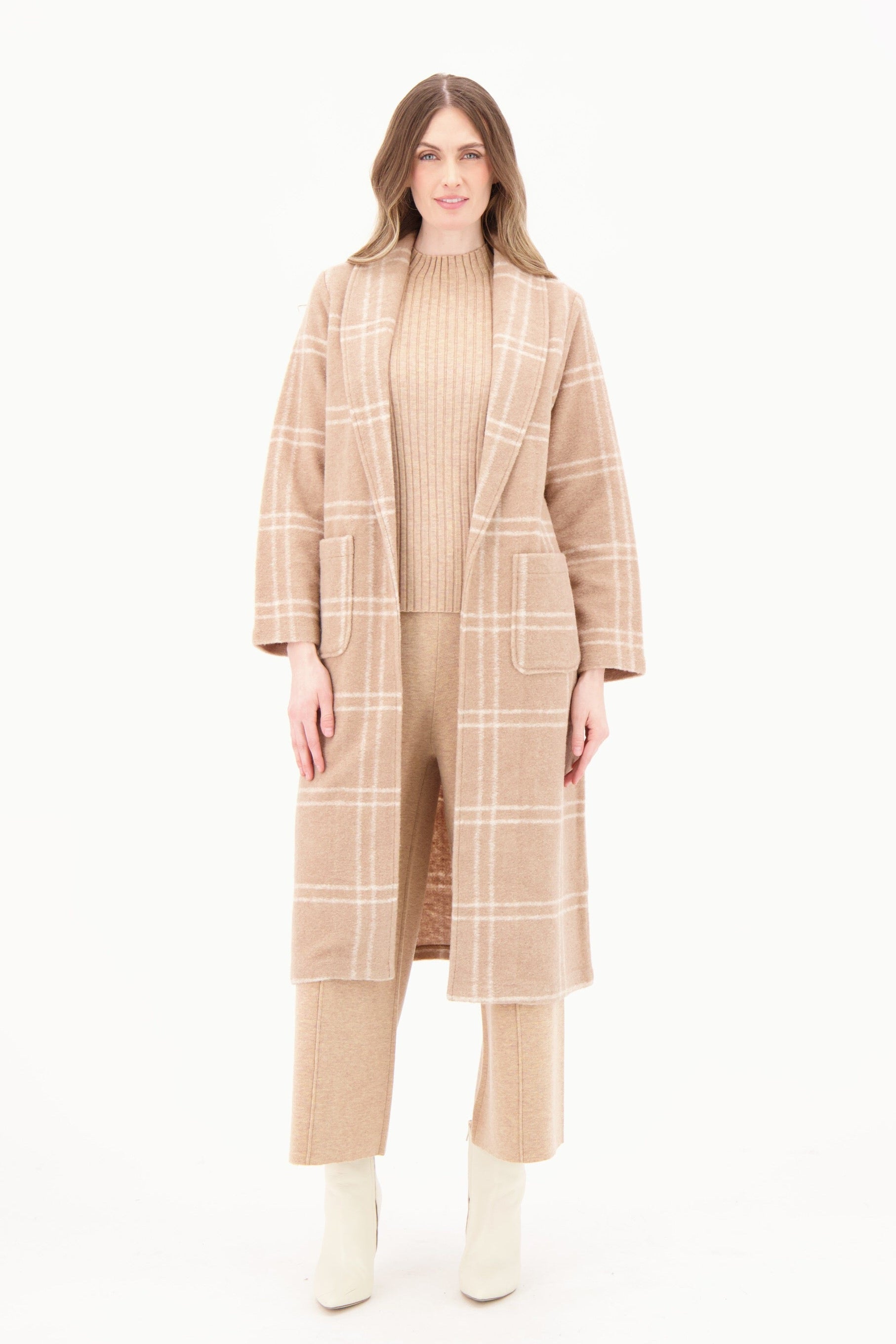 Woman wearing a beige checkered coat and pants on a white background
