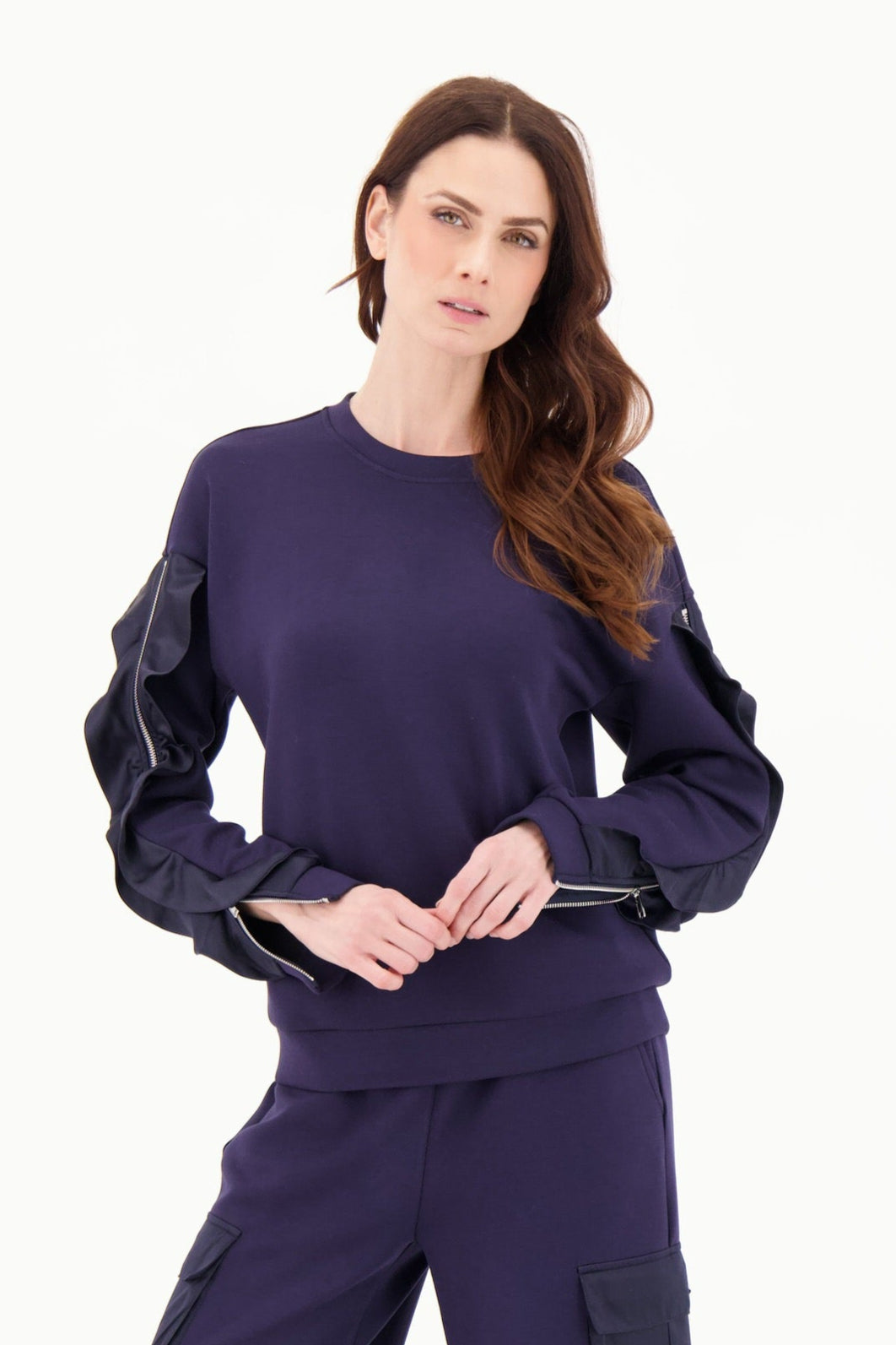 Woman wearing a navy blue outfit with cargo pants on a white background