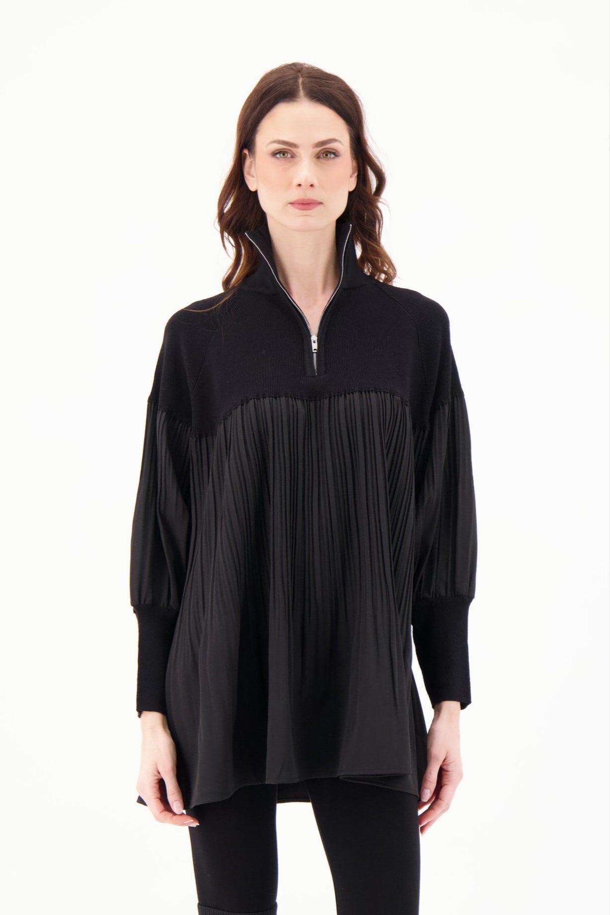 Woman wearing a black long-sleeve top with a zipper on a white background