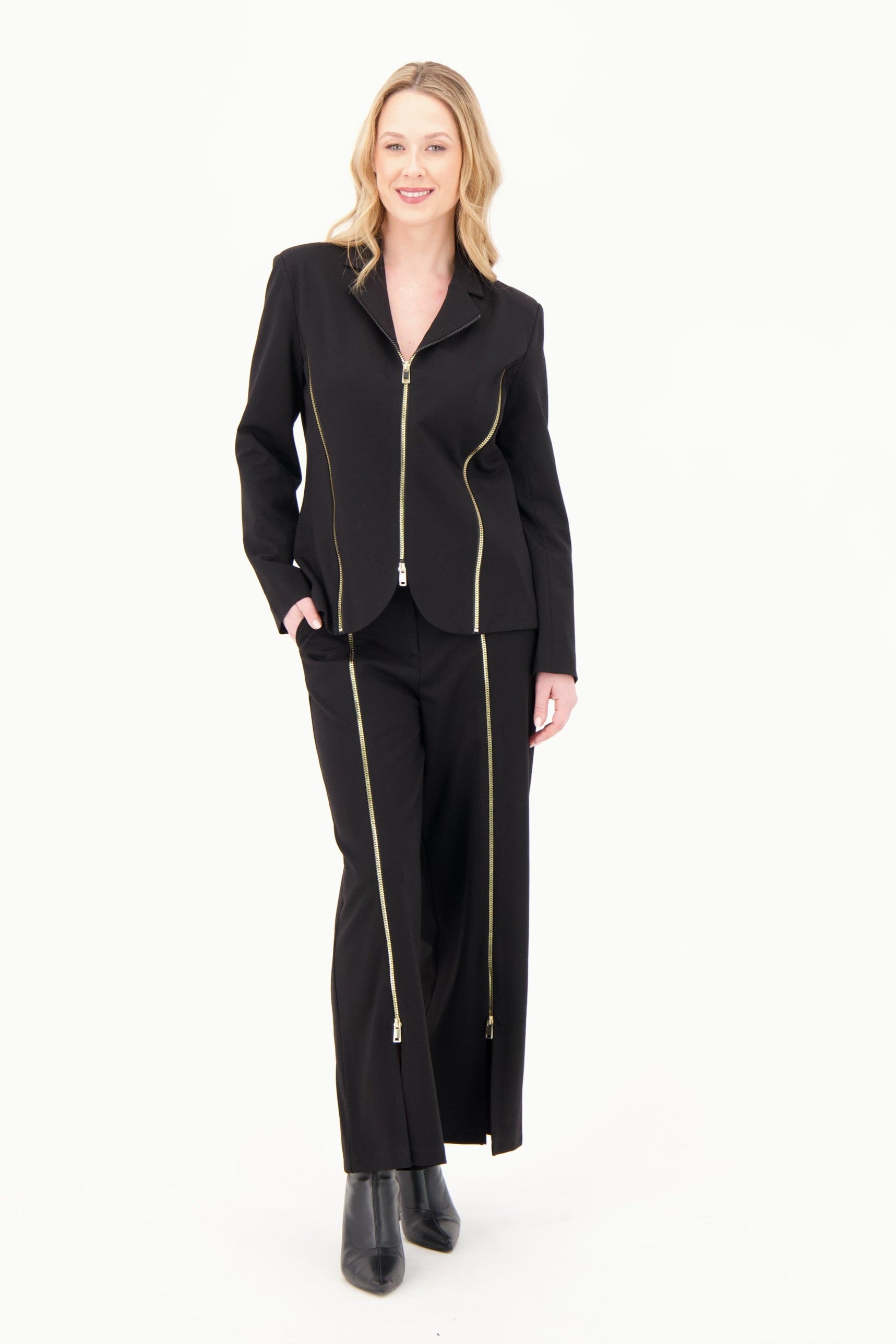Woman wearing a black suit with gold zippers on a white background 