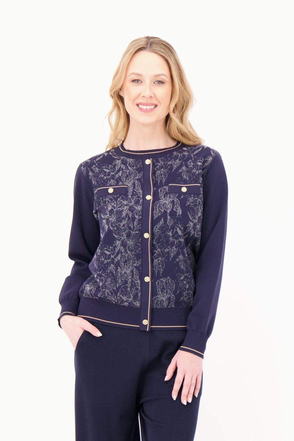 Woman wearing a navy blue cardigan with a floral pattern on a white background