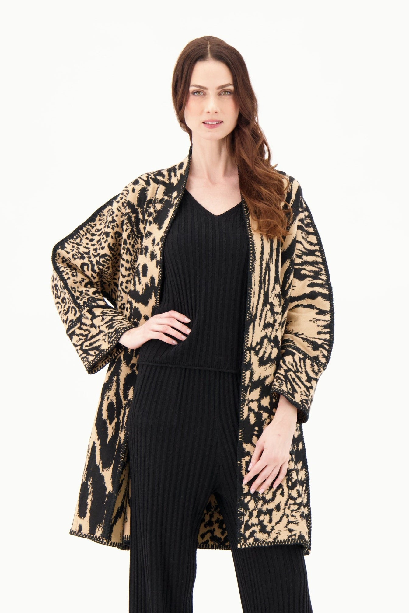 Woman wearing a leopard print coat over a black outfit on a white background