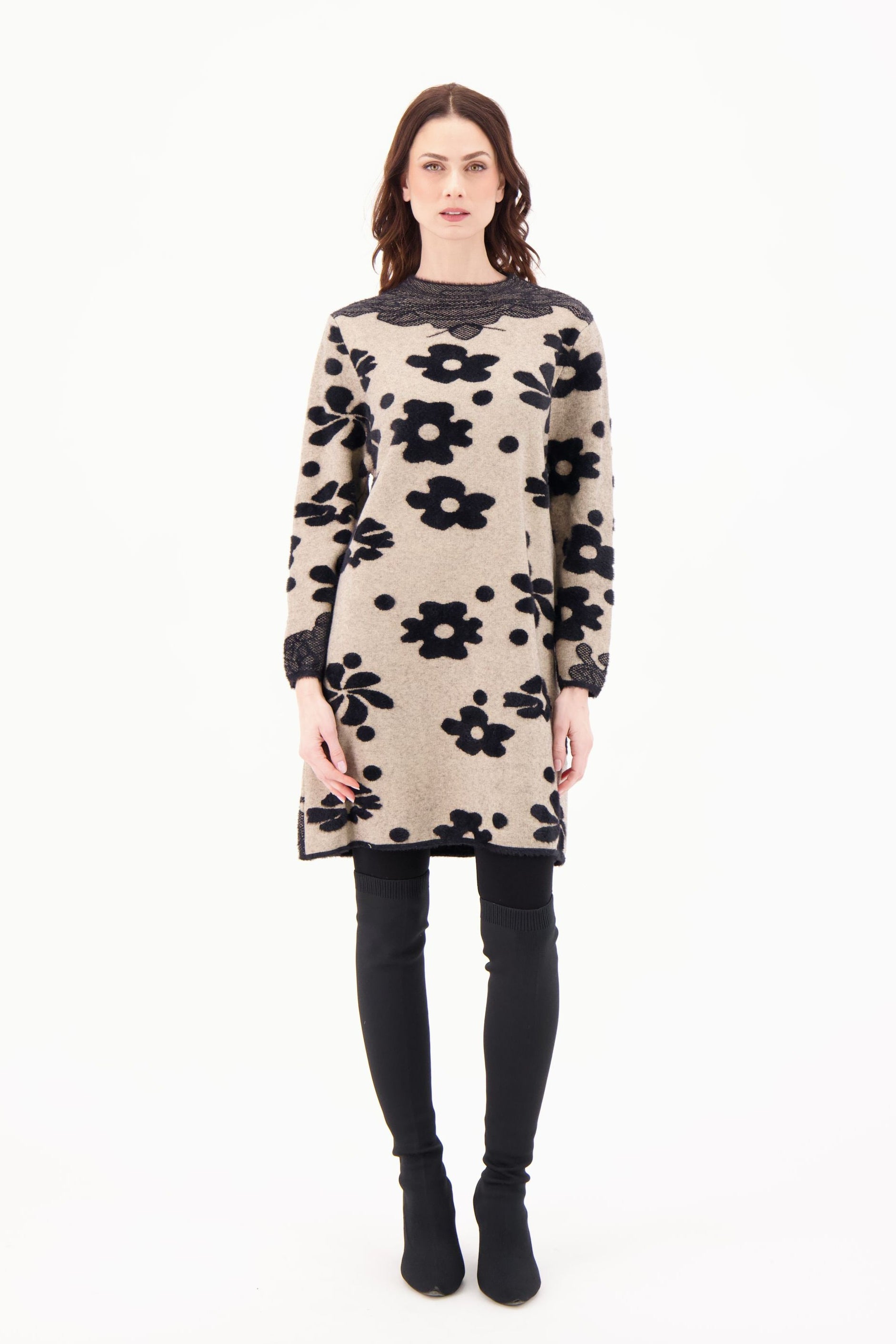 Woman wearing a beige dress with black floral pattern on a white background