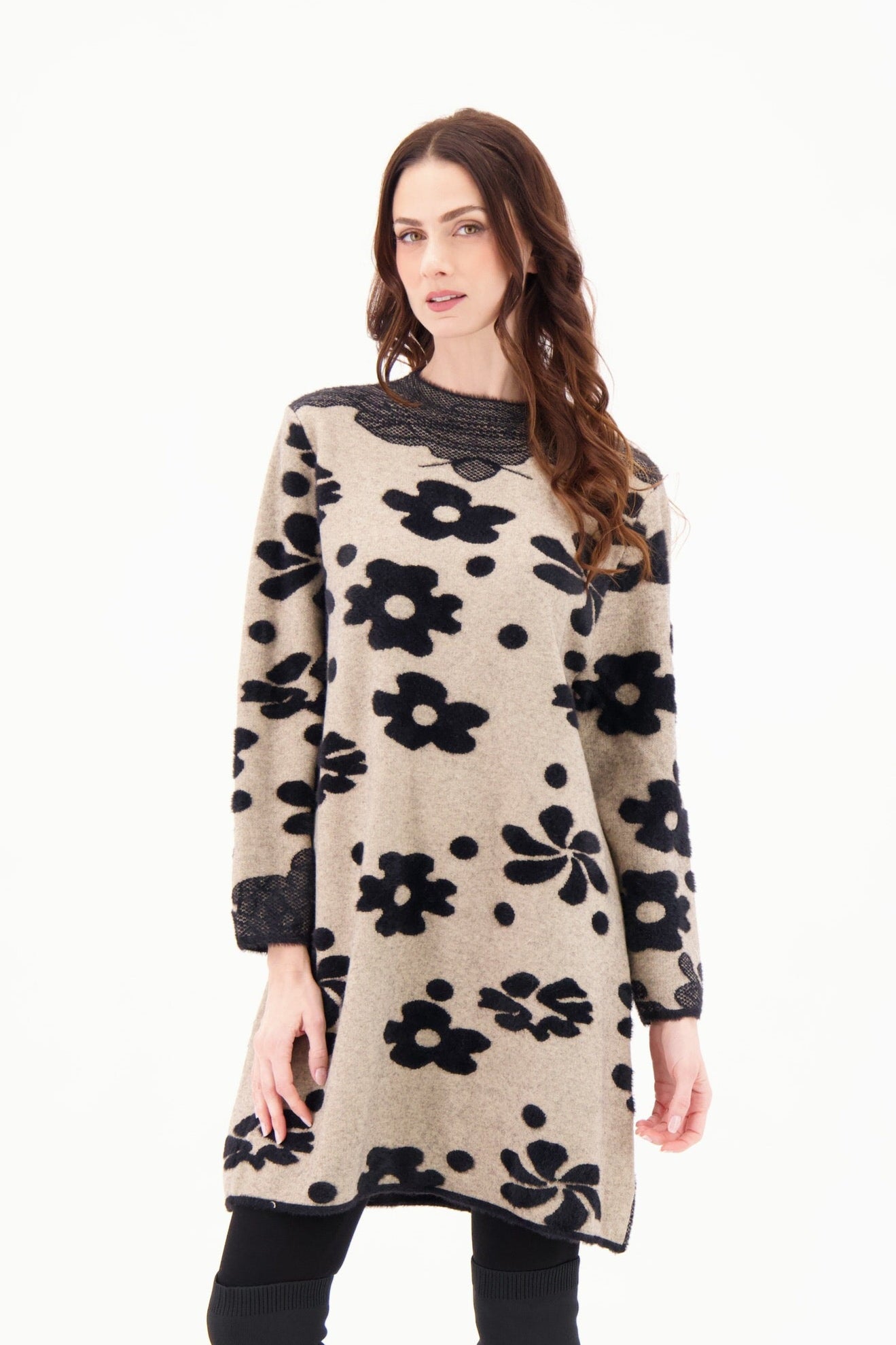 Woman wearing a beige dress with black floral patterns on a white background