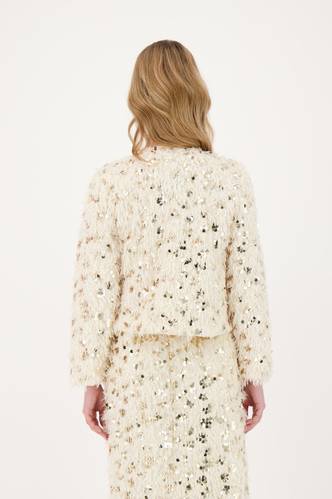 Woman wearing a floral dress and cardigan set on a white background