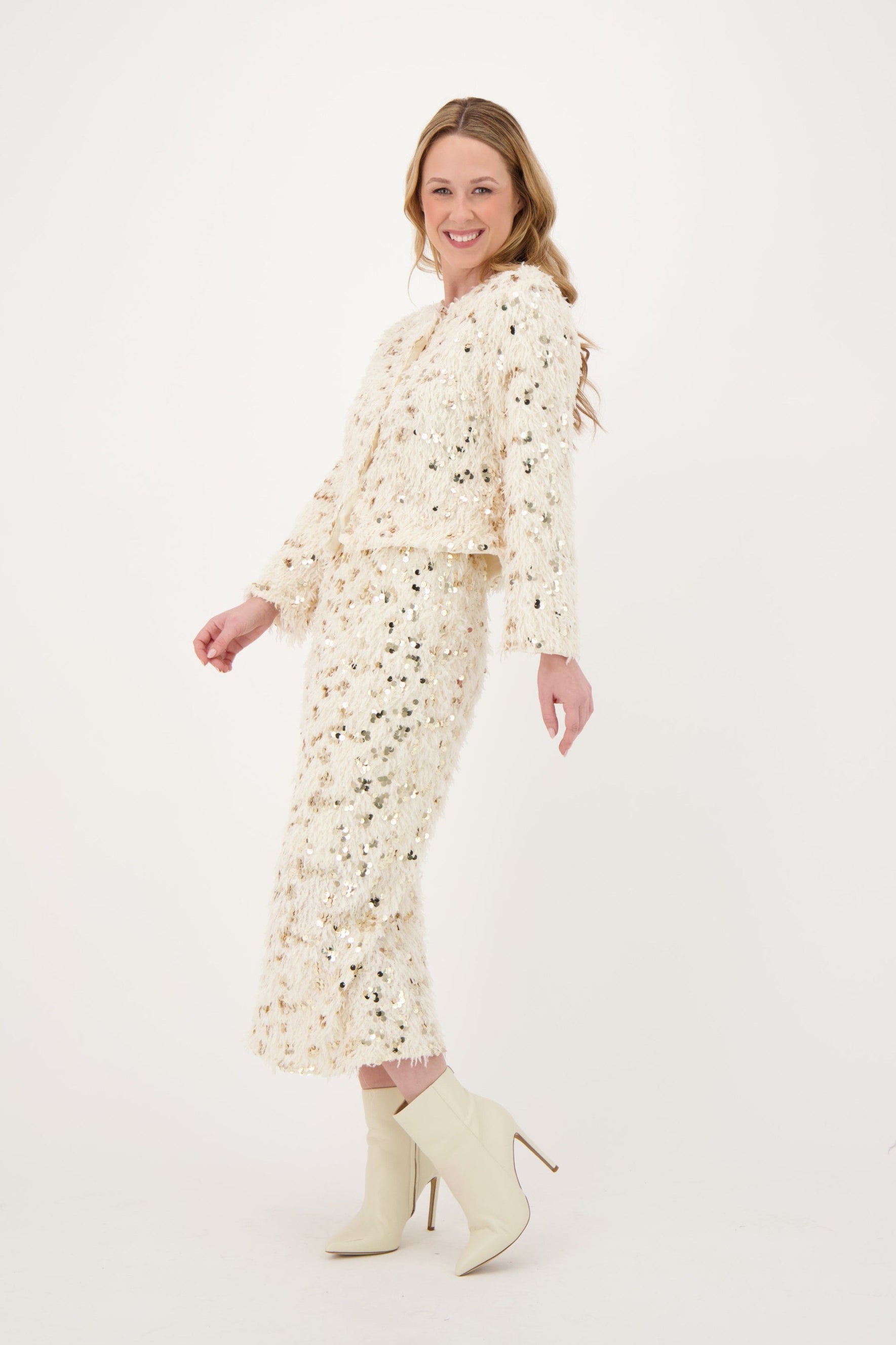 Woman wearing a floral dress and white boots on a white background