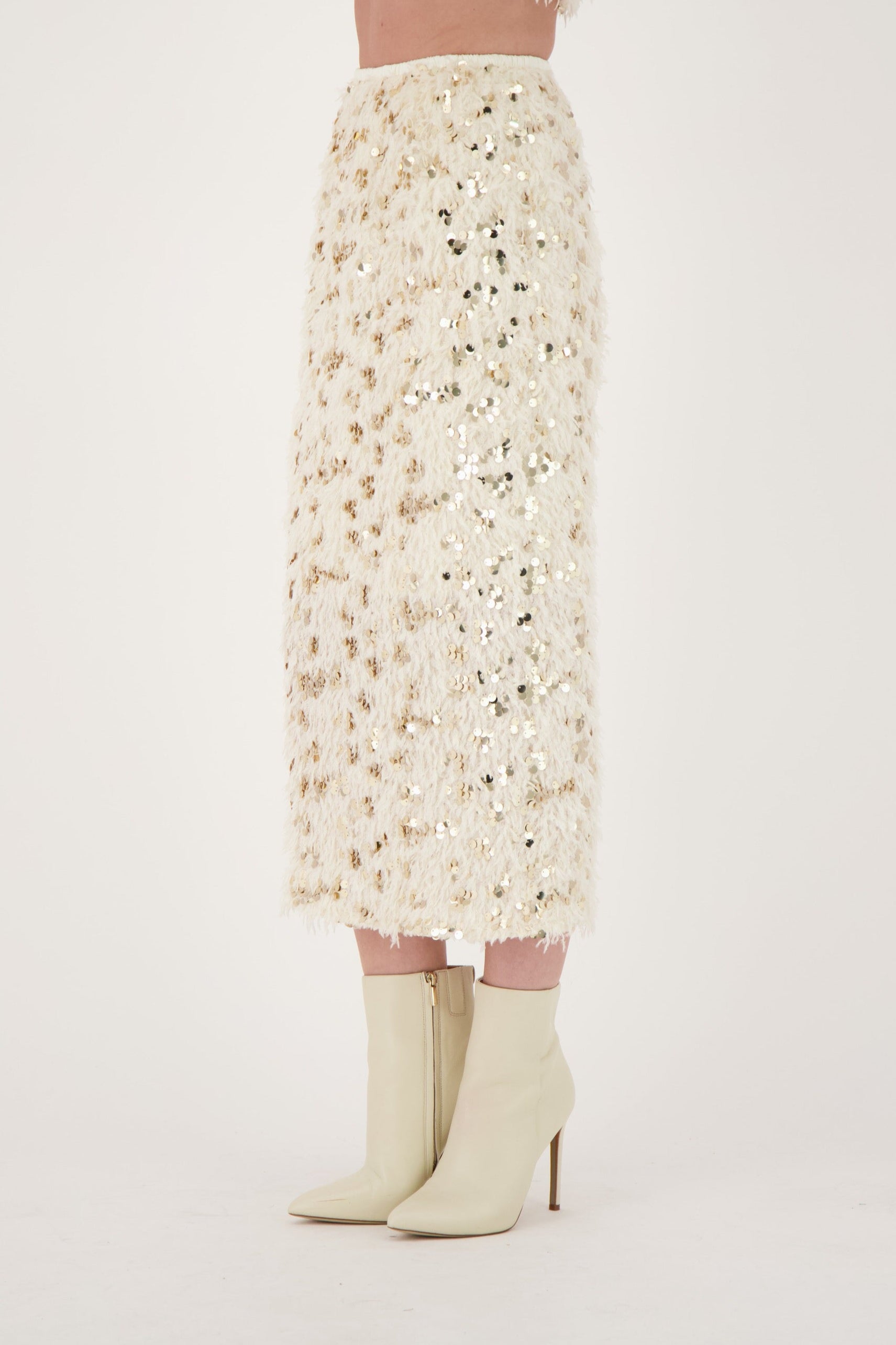 Person wearing a floral skirt and white boots on a plain background